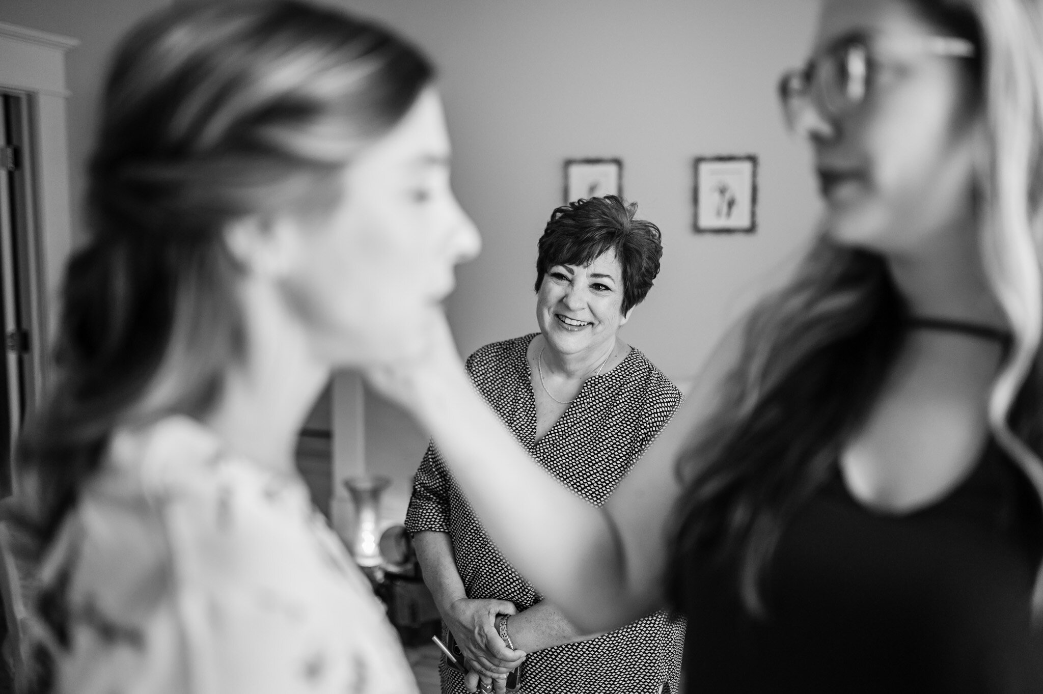 Mom looks at her daughter getting ready on her wedding day