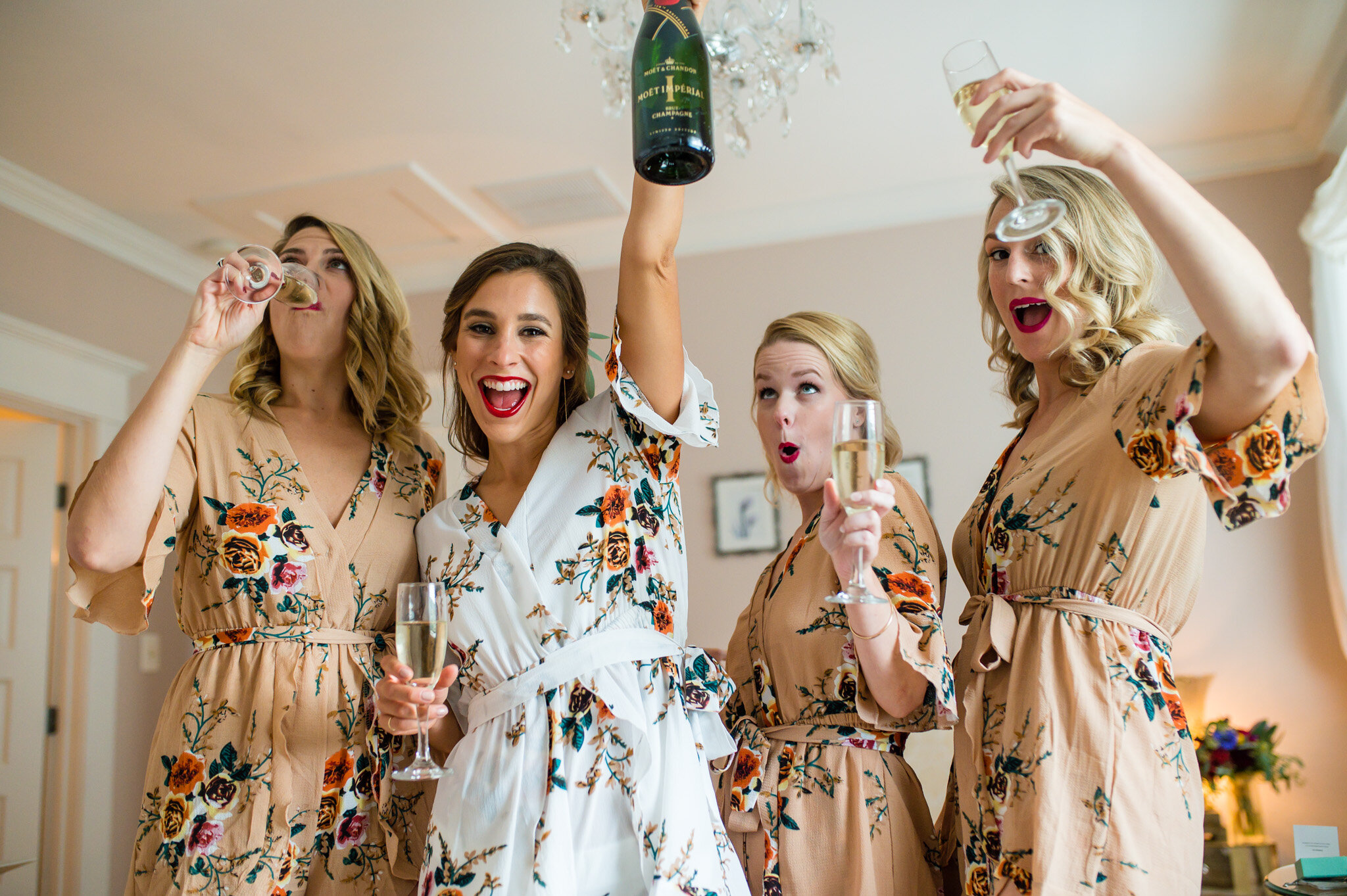 bride and her bridesmaids celebrate with champagne
