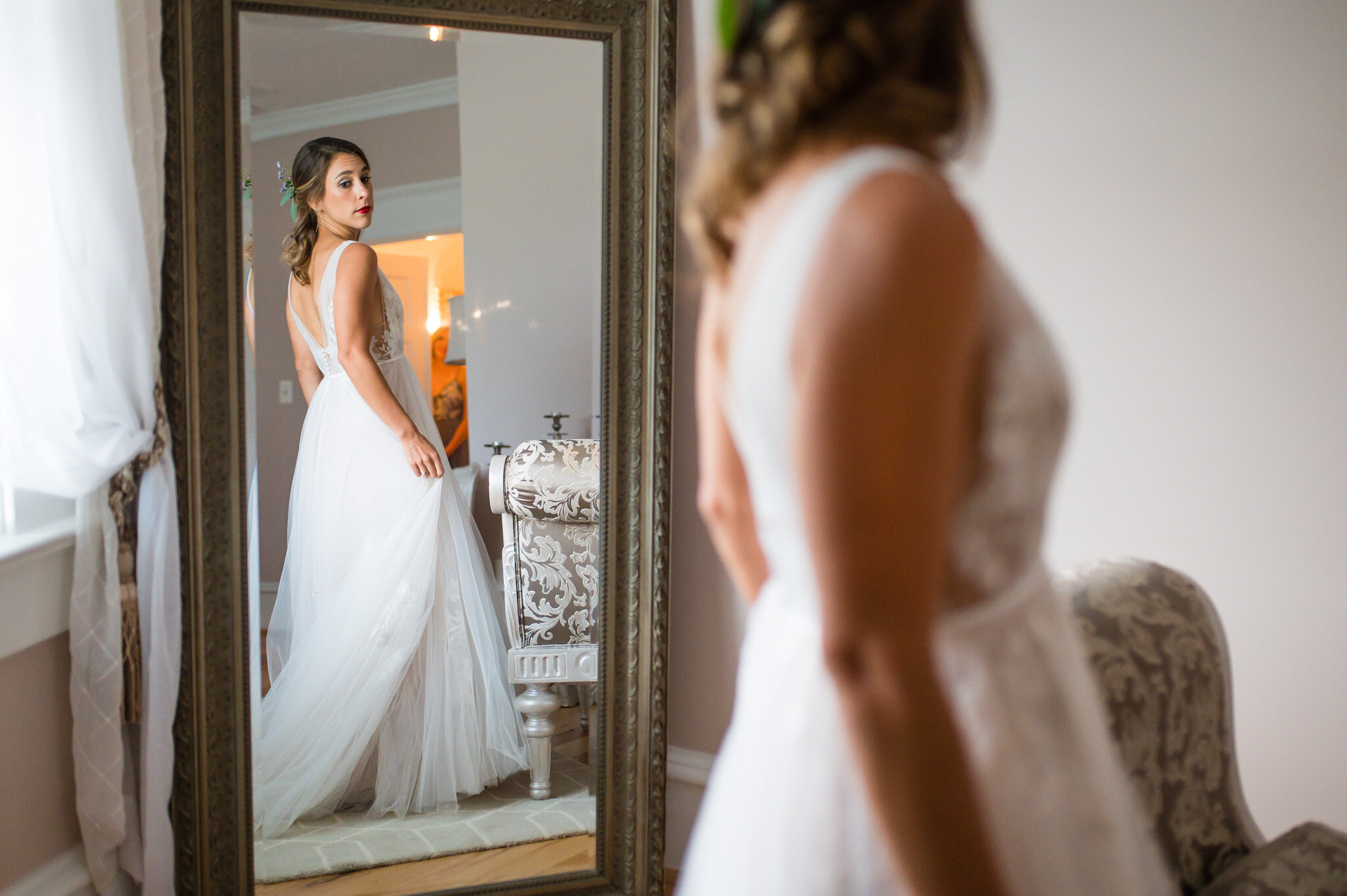 Bride admires her wedding dress in a mirror