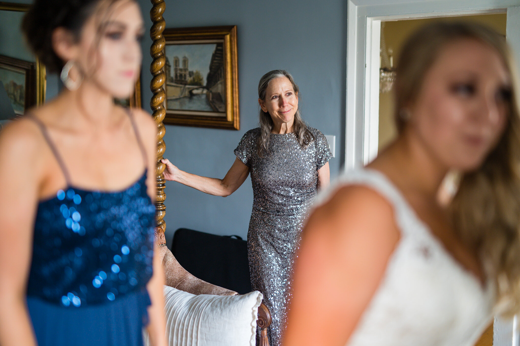 Mom looks at her daughter finishing her wedding preparations