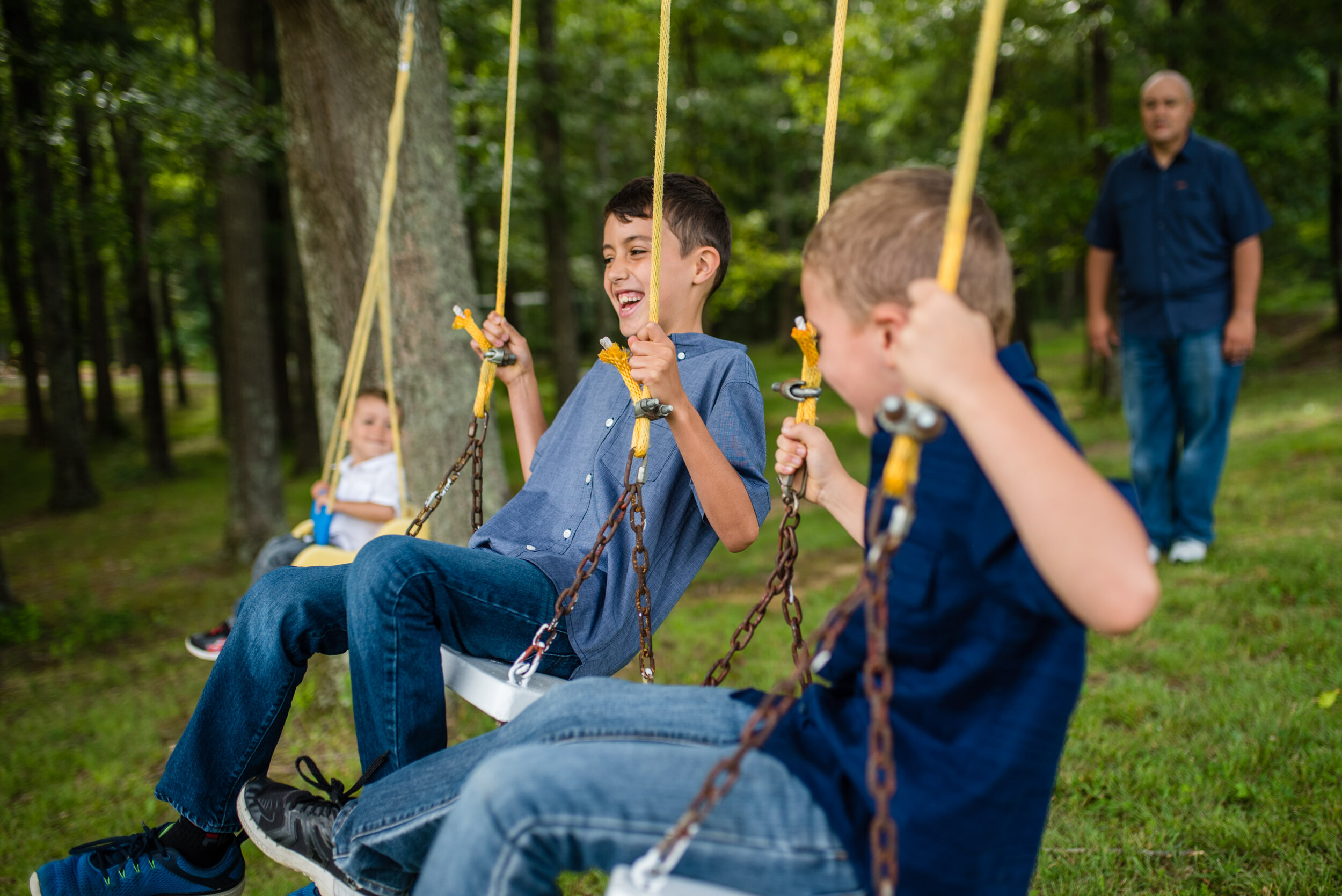 Three boys playing on the swings during a family photography session