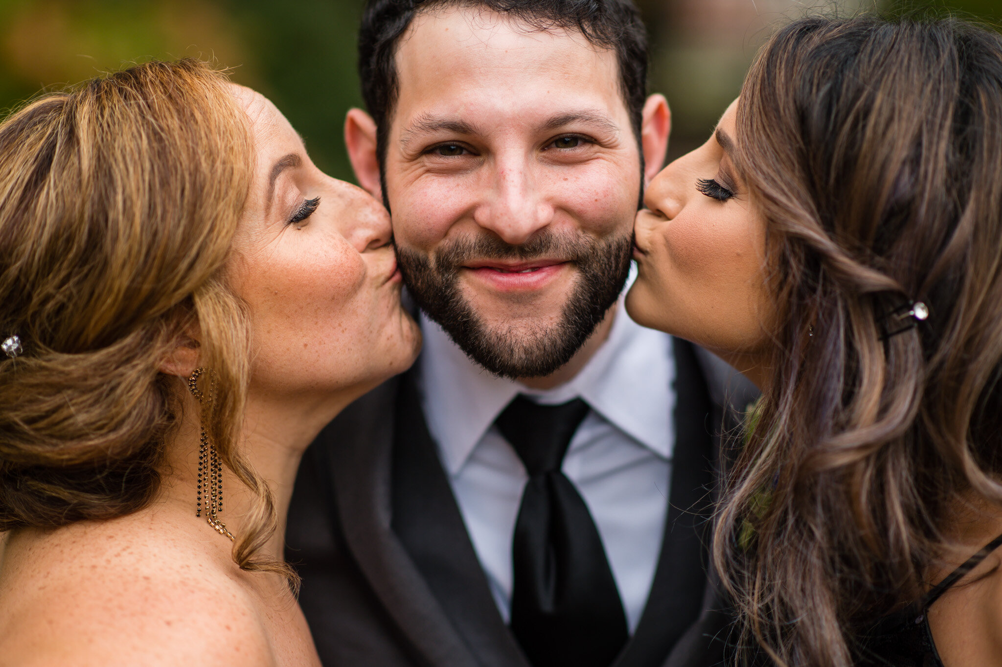 The groom and his two sisters share a moment together
