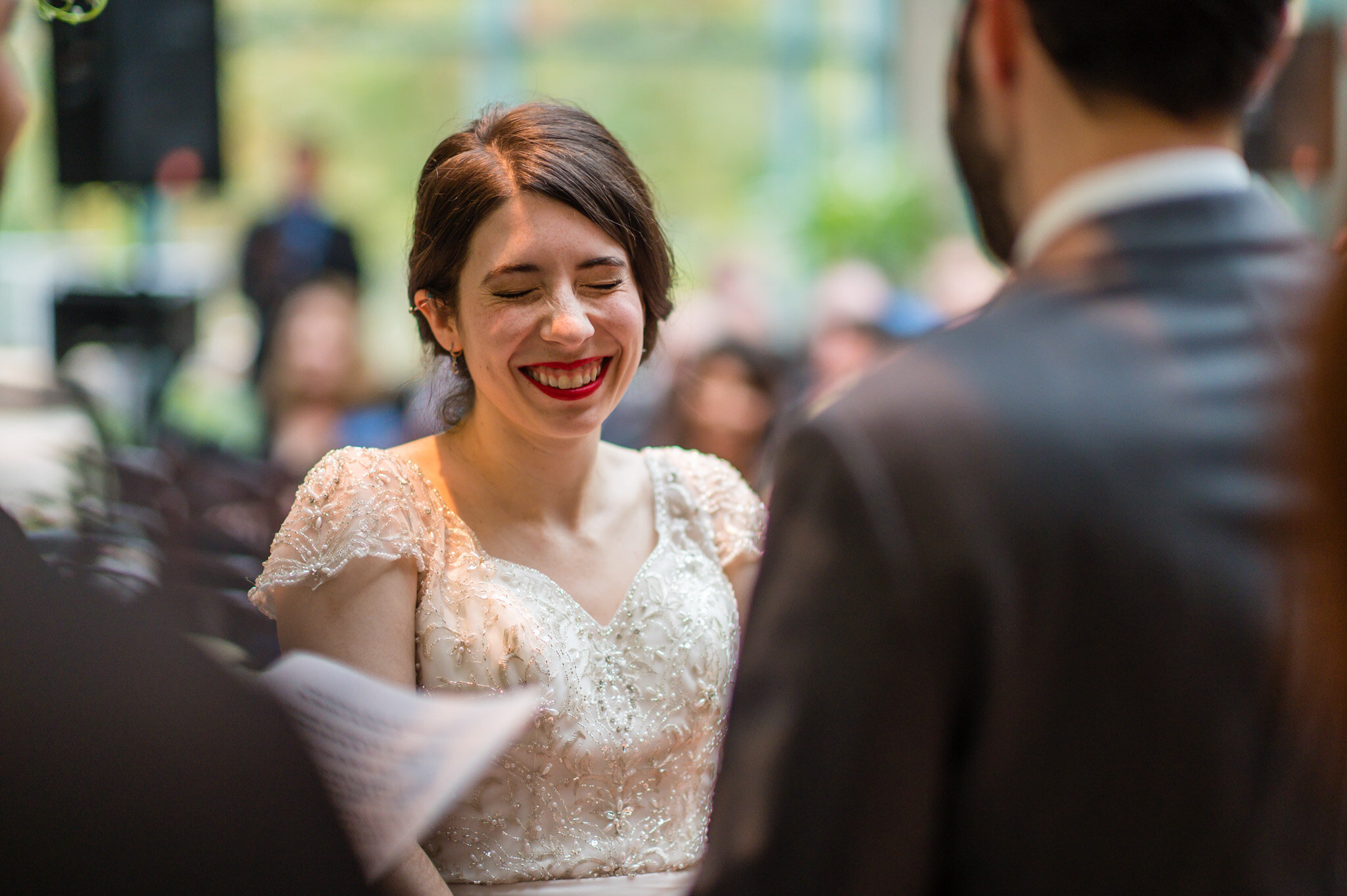The bride and groom share a laugh at their jewish wedding ceremony