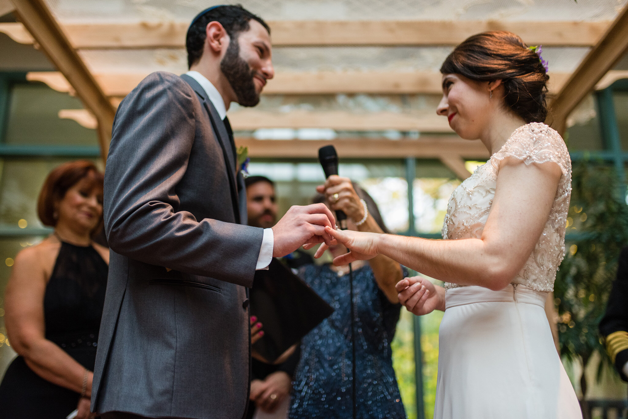 Groom places the ring on his bride's finger at their jewish wedding ceremony
