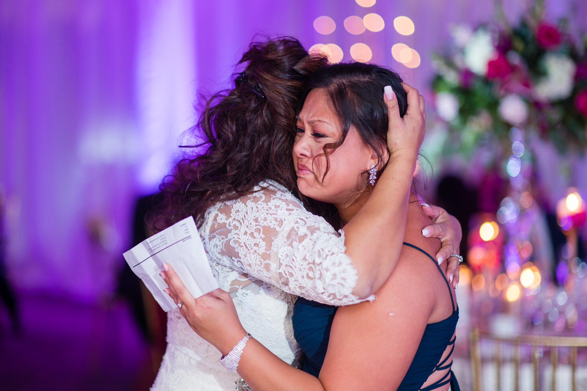 Bride and maid of honor sharing a hug at a wedding in Leesburg Virginia