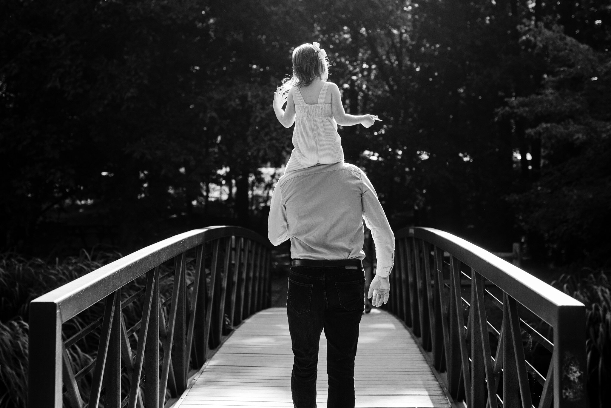 Daughter riding on her father's shoulders.