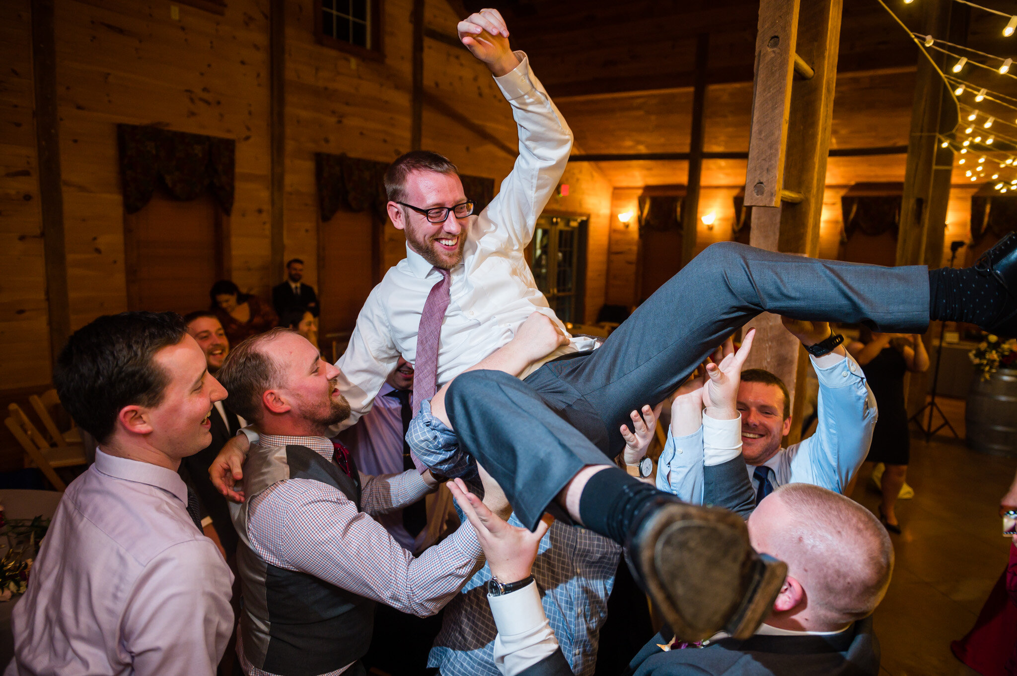 groom being carried at wedding reception