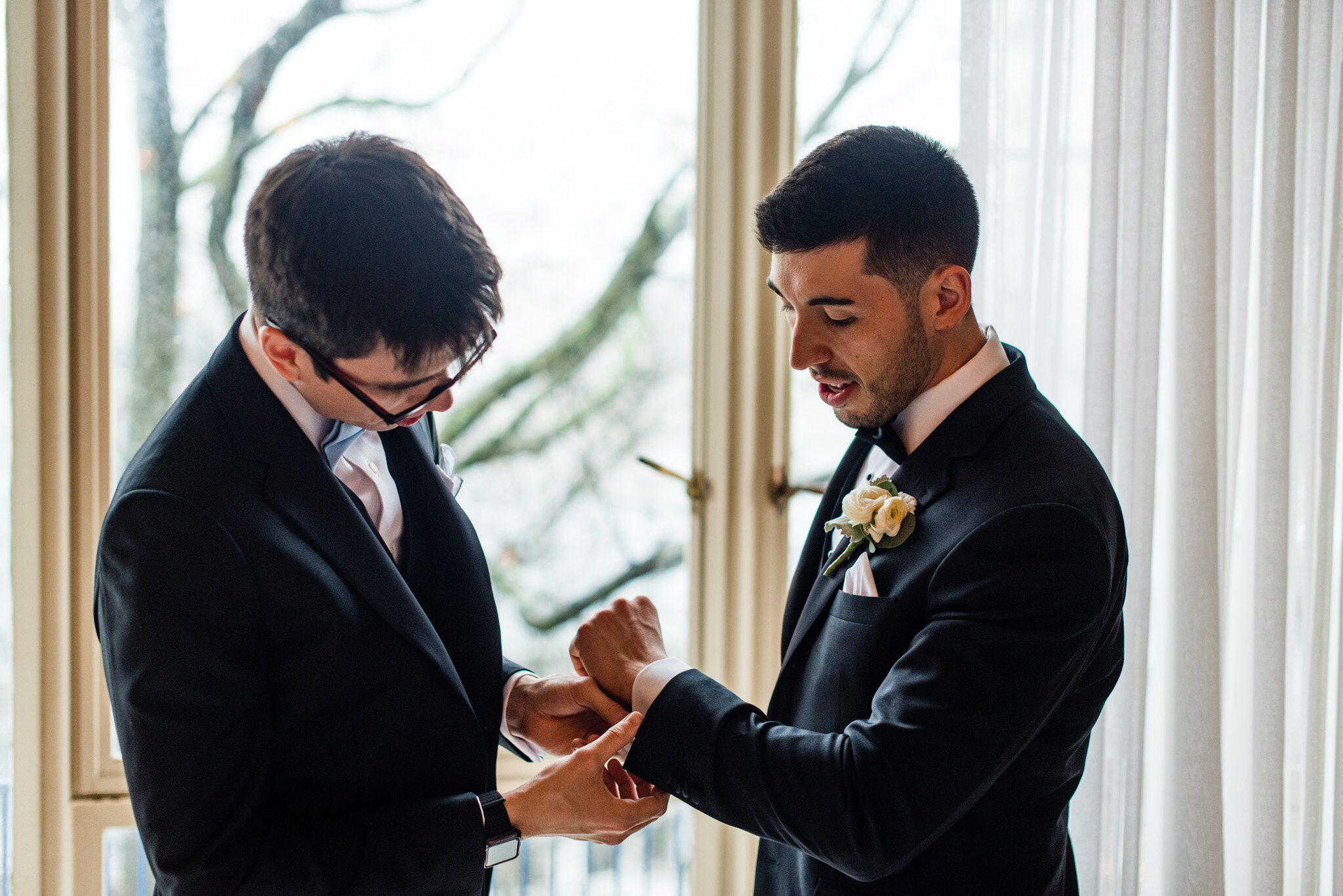 Groom with best man putting on cuff links