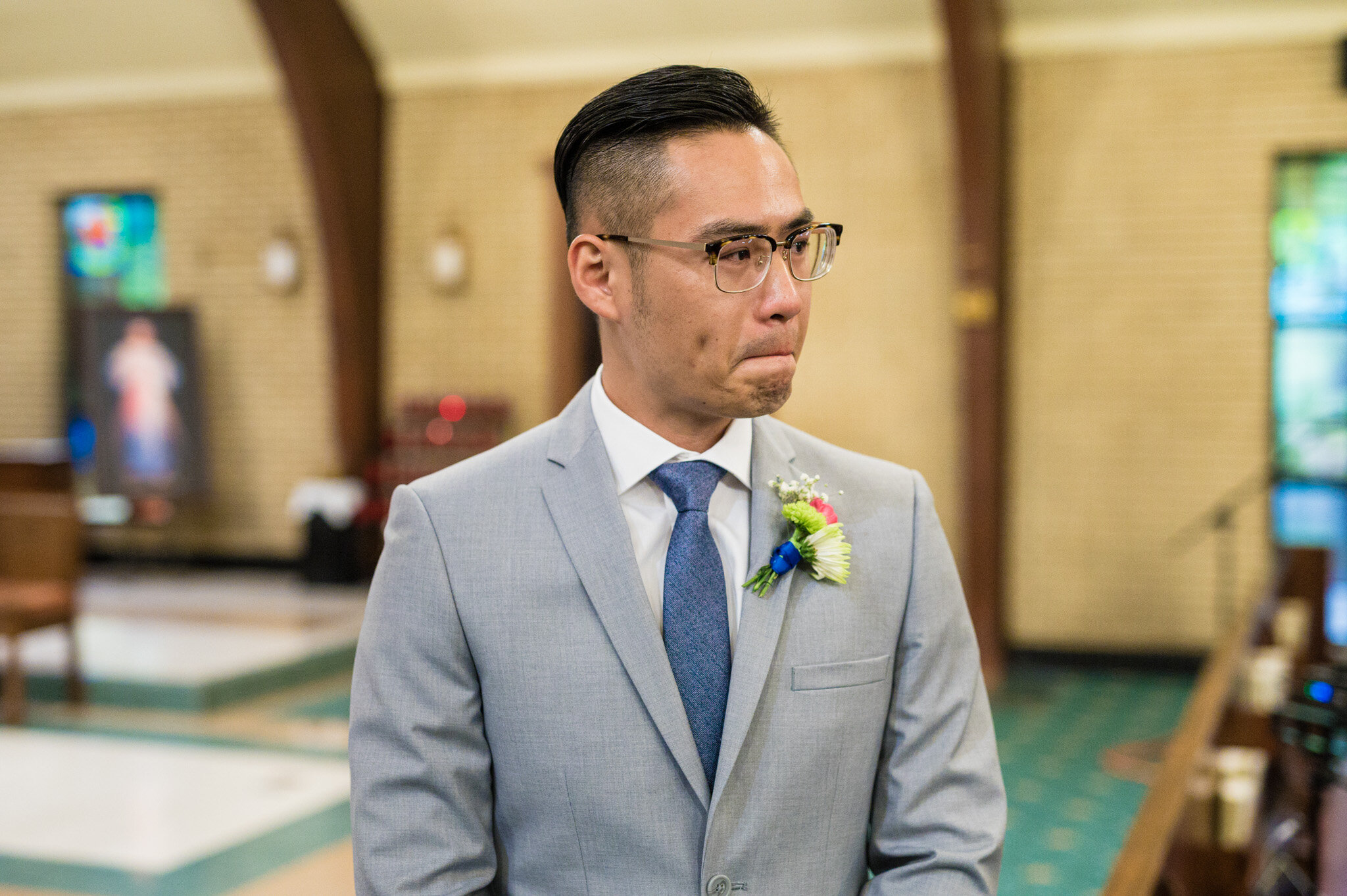 A groom's emotional reaction to seeing his bride walking down the aisle