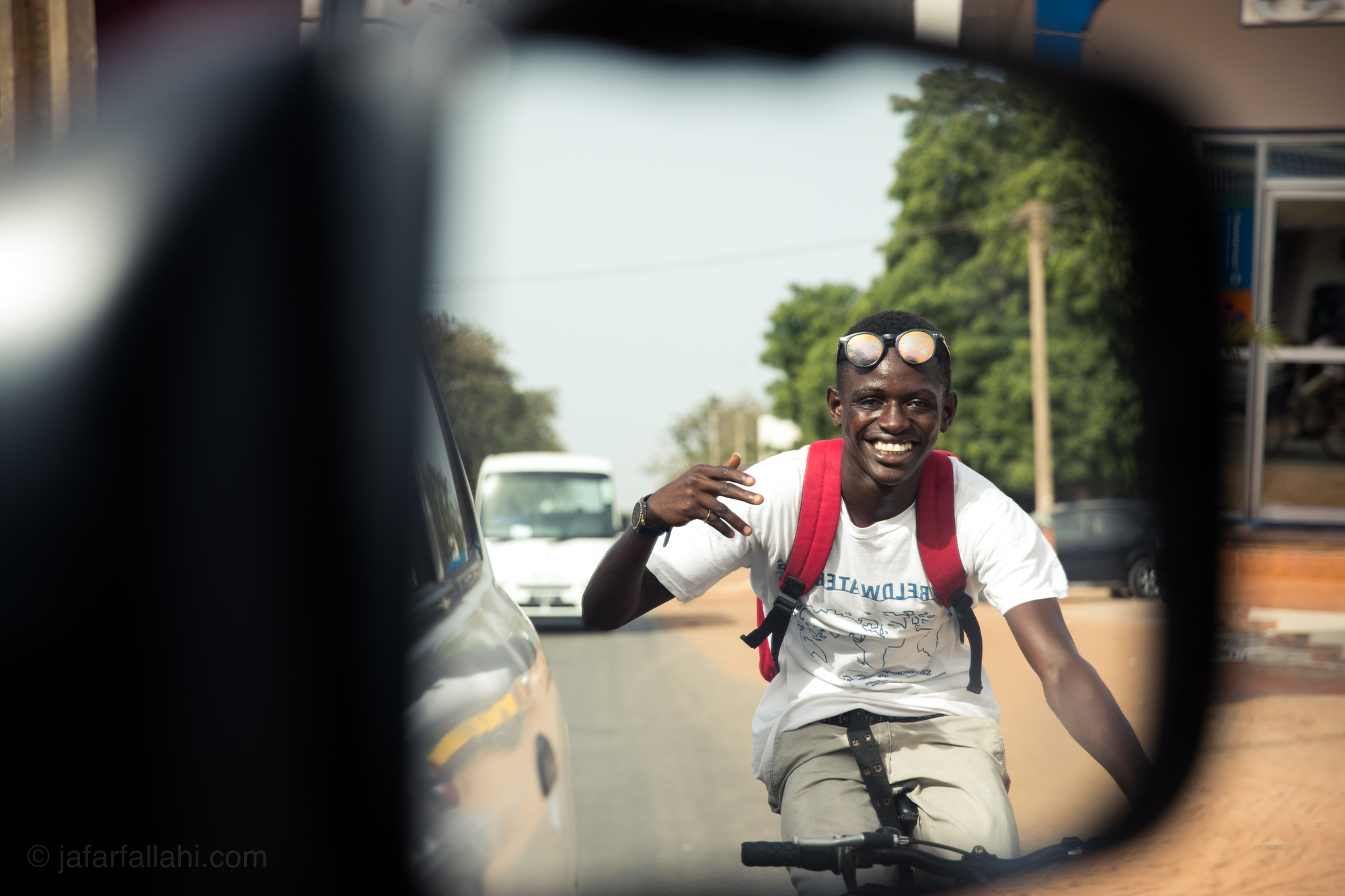 This guy was using our truck to tow him around town. As soon as he saw me taking his picture through the rear-view mirror he smiled and waved.