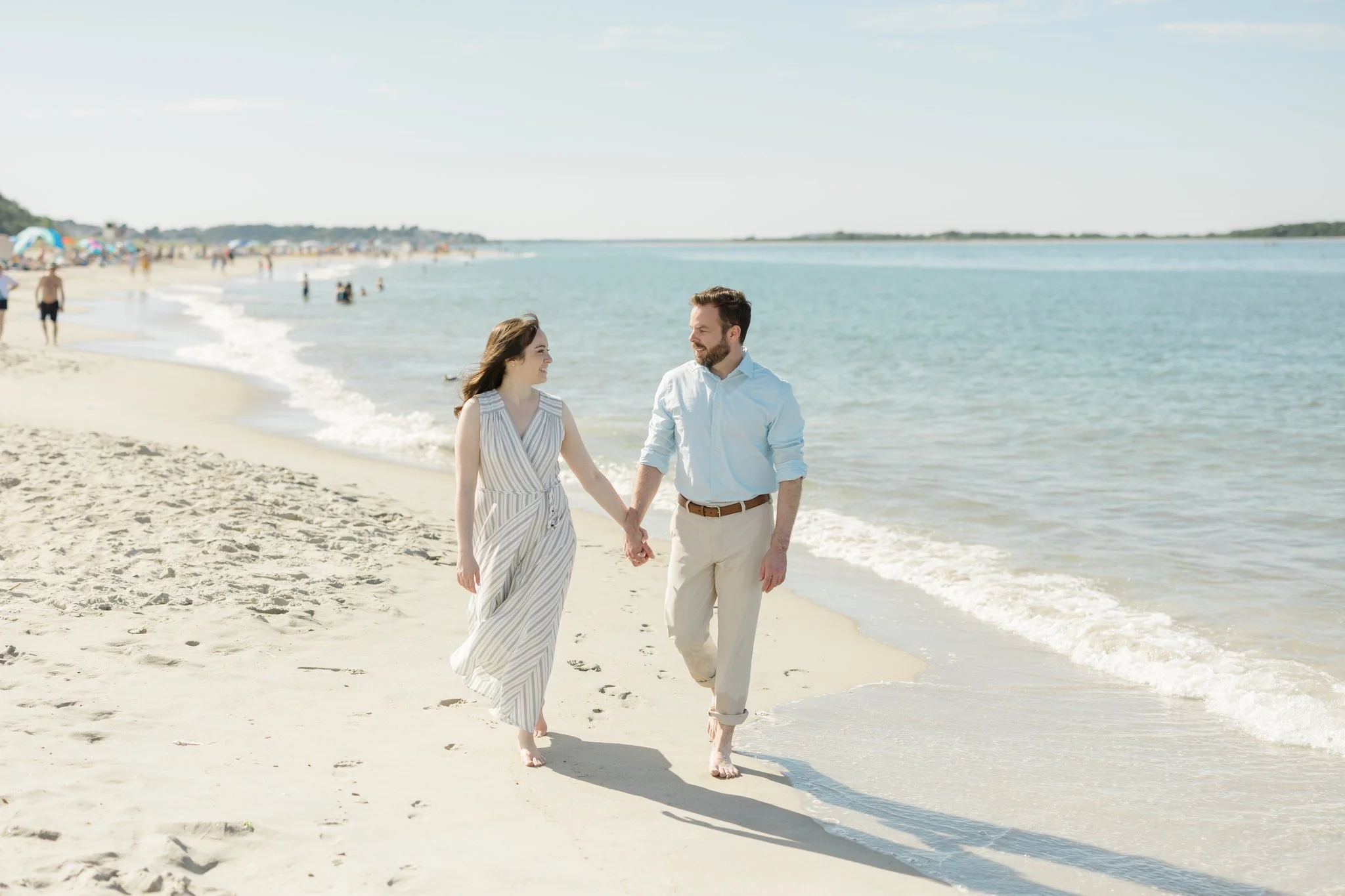 Couple walking along the seashore during engagement session on crane beach in ipswich