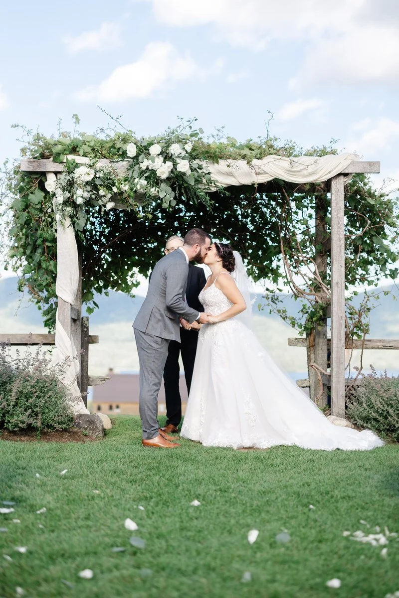 Bride and groom kiss at end of aisle during ceremony at Mountain Top Inn Vermont Wedding