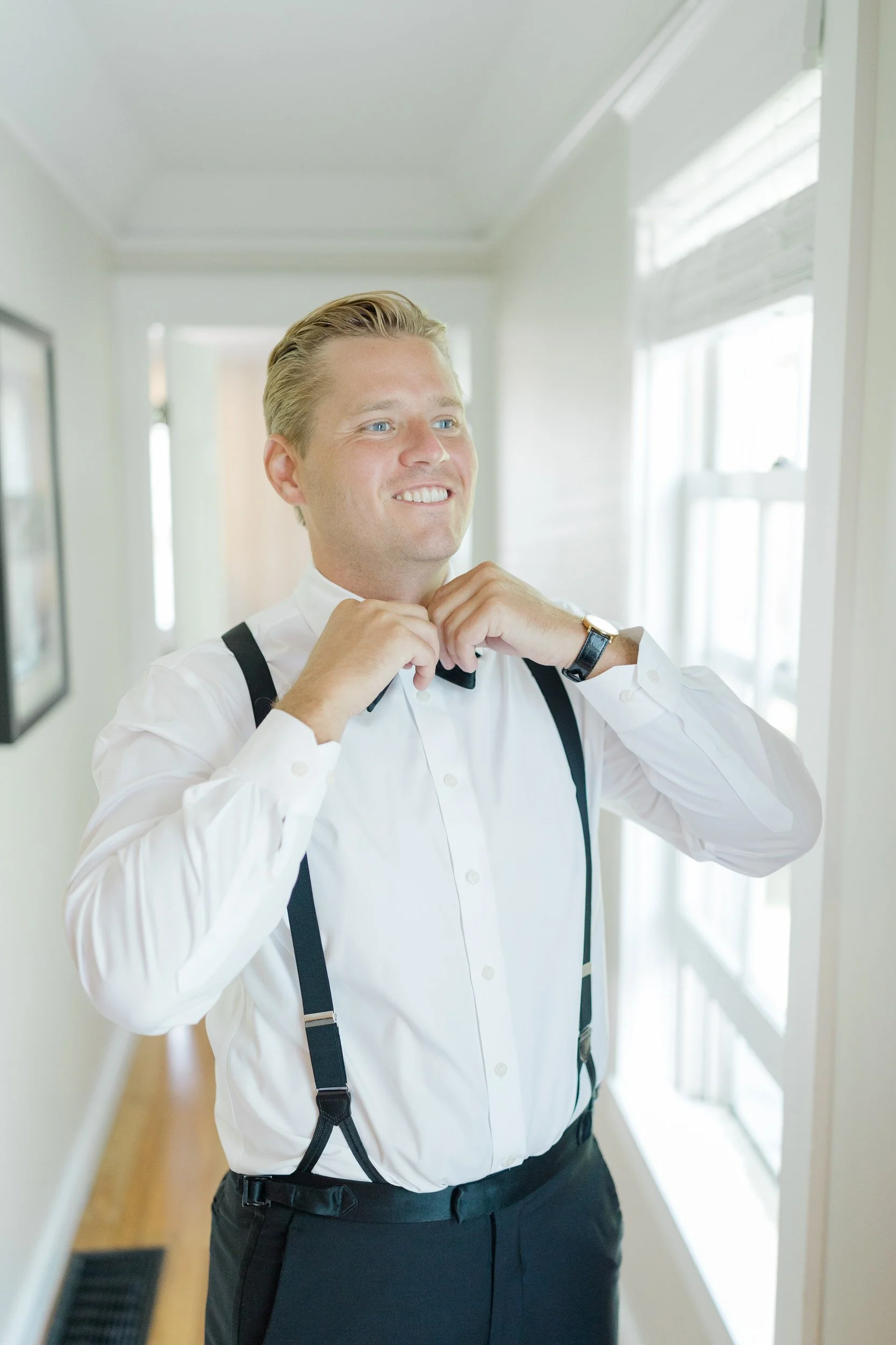 Groom fixes his bow tie at the Equinox Golf Resort & Spa Wedding