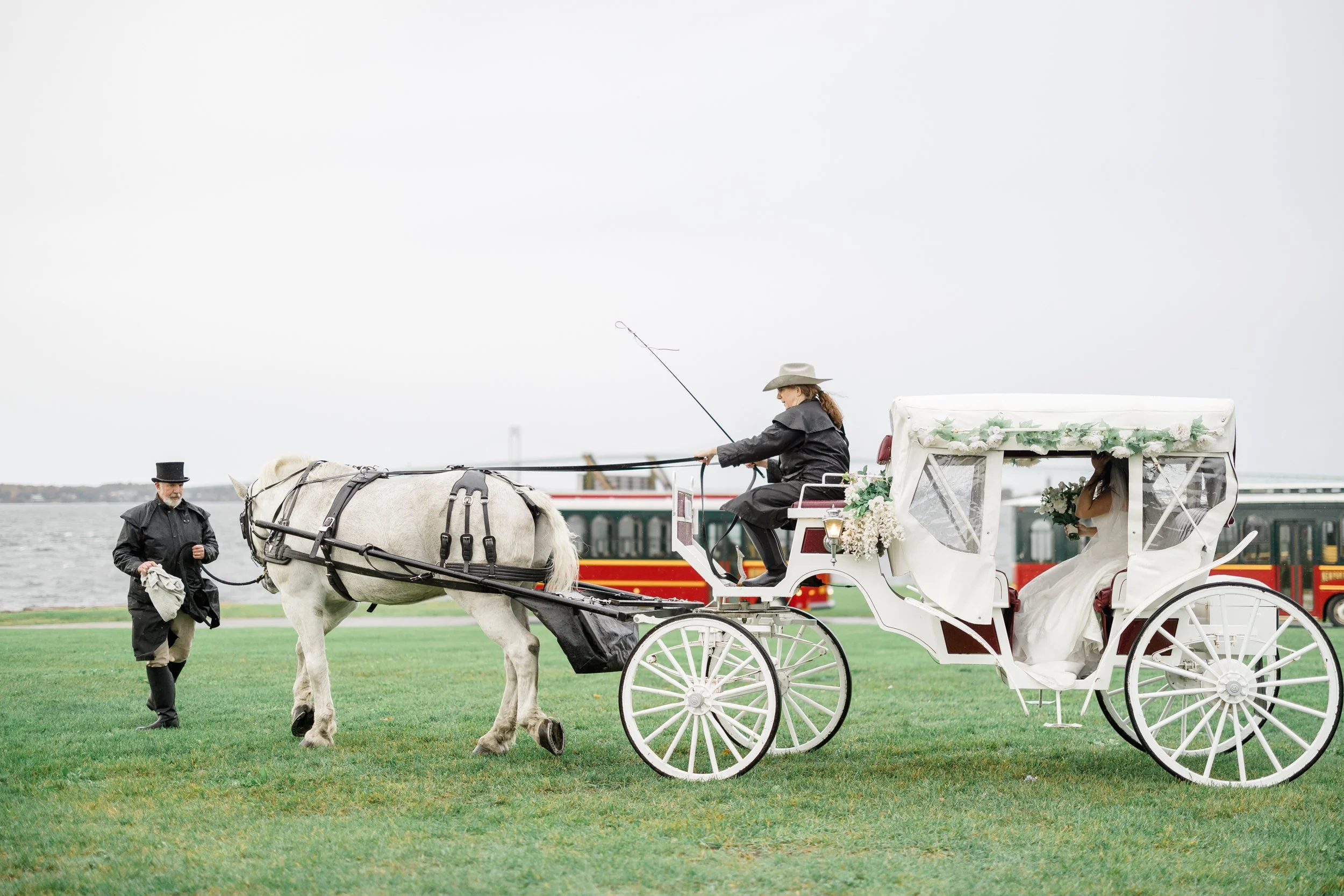 Bride arrives to her wedding ceremony at Fort Adams in horse and carriage