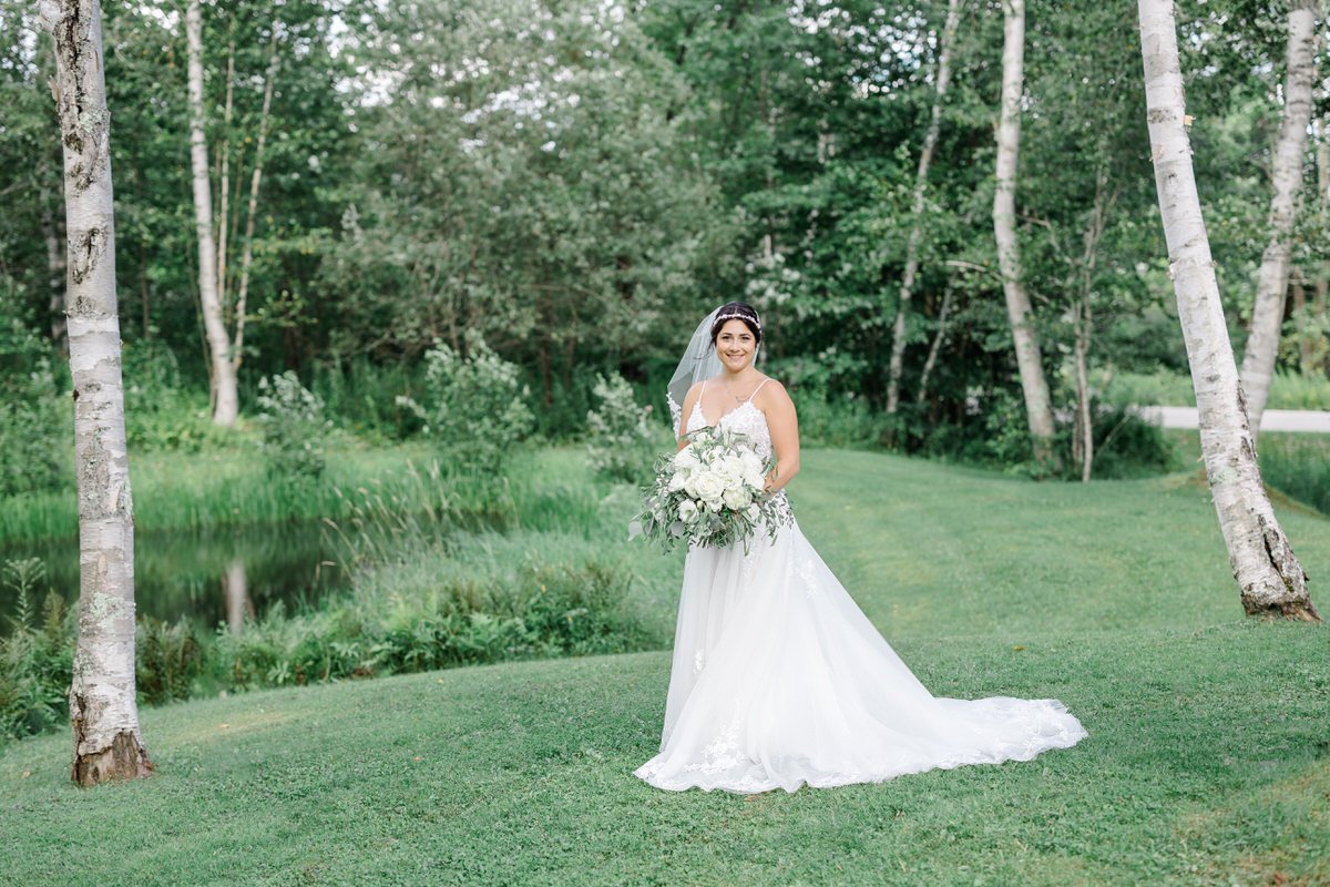 Bride smiles and holds bouquet at Mountain Top Inn Vermont Wedding