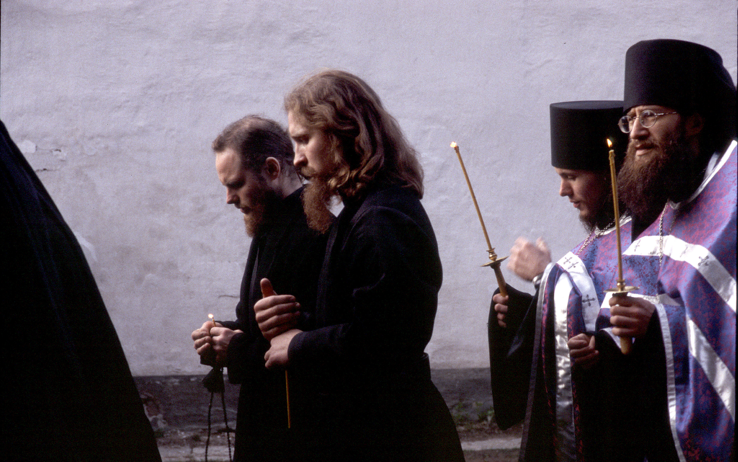 Monks walking in a procession around the monastery cathedral during the religious holiday of Apostles Peter and Paul.