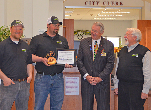 Zach Dieterman, field coordinator, Dustin Looman, assistant manager, both from the Southern District, and at far right, Len Price, executive director, accepted the award from Mayor Brede.
