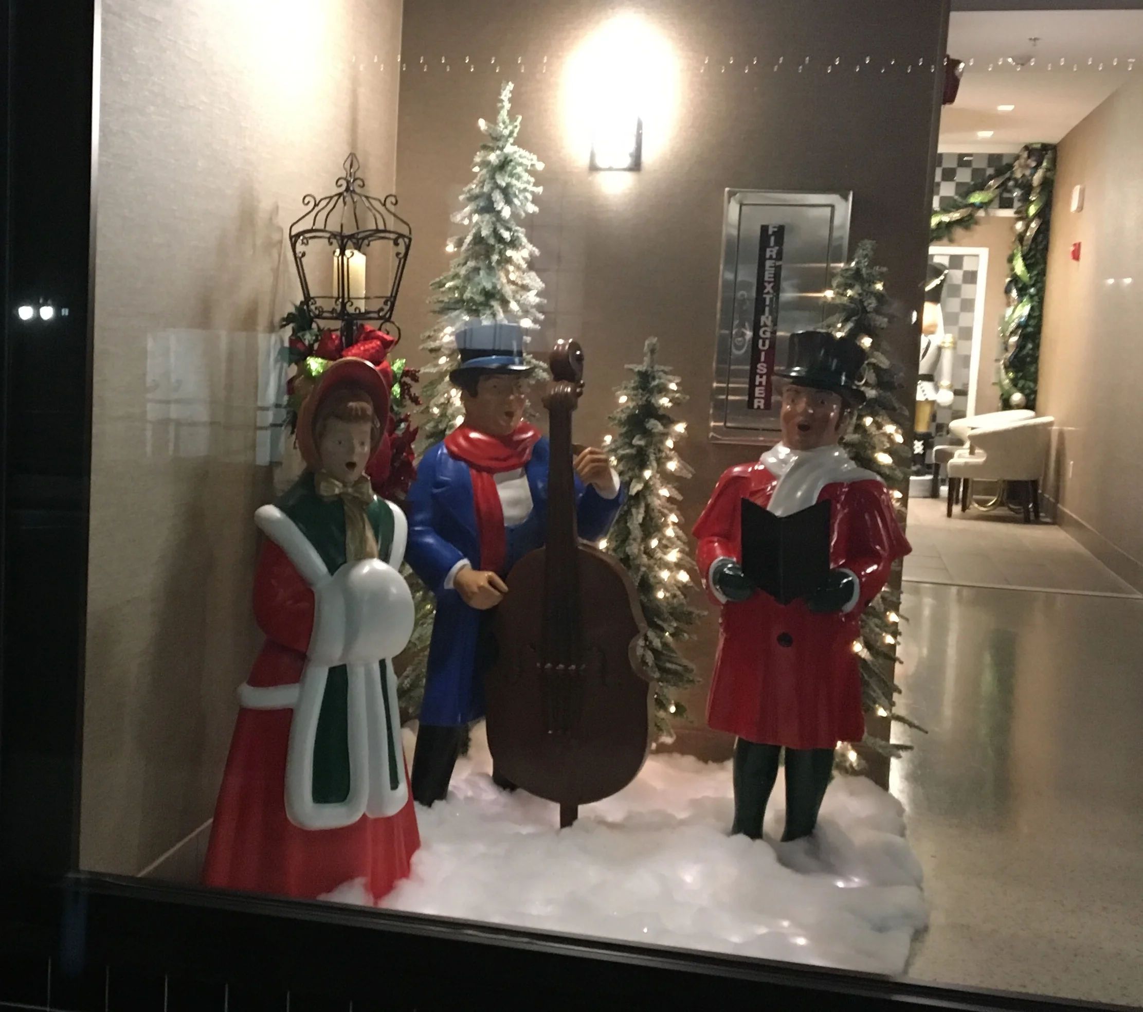 Fountain Street Entrance. Fiberglass scene of carolers, LED lights, faux snow and additional accessories. 
