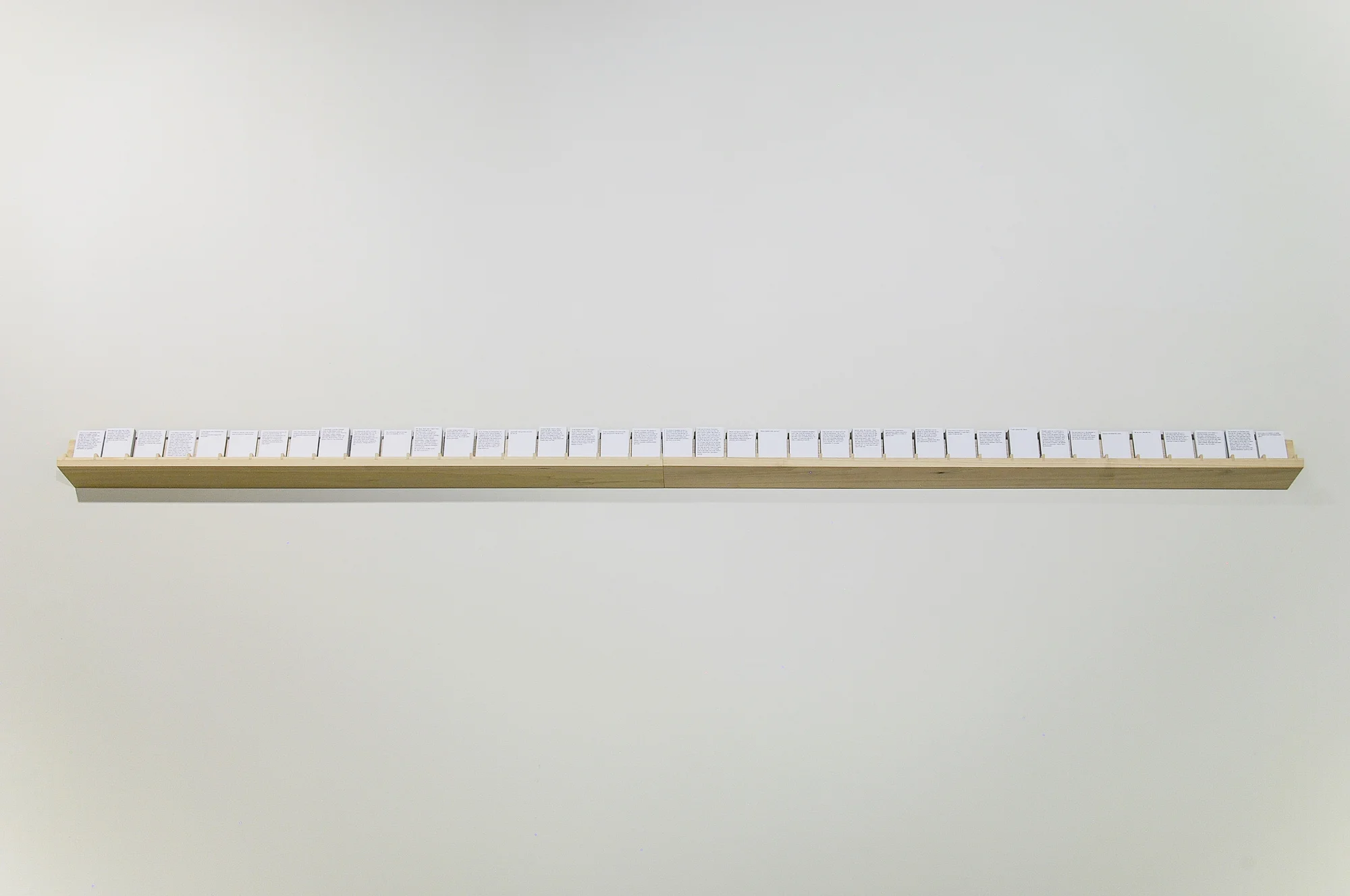 As Ashes or An Overcast Sky: Variations on Gray | 2012 Printed cards, wooden shelf. 83 inches wide. Visitors were allowed to take cards freely, and cards were replenished during the duration of the exhibition. For the full text, click here. 