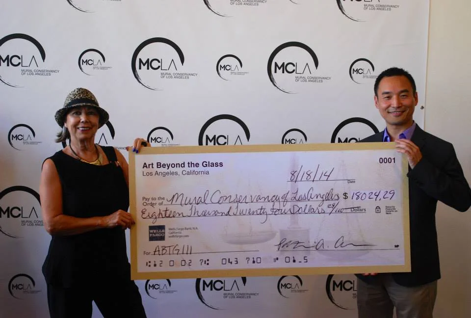 ABTG Co-Founder Daniel Djang presents the ABTG III donation check to Mural Conservancy Executive Director Isabel Rojas-Williams | Photo courtesy of Mural Conservancy