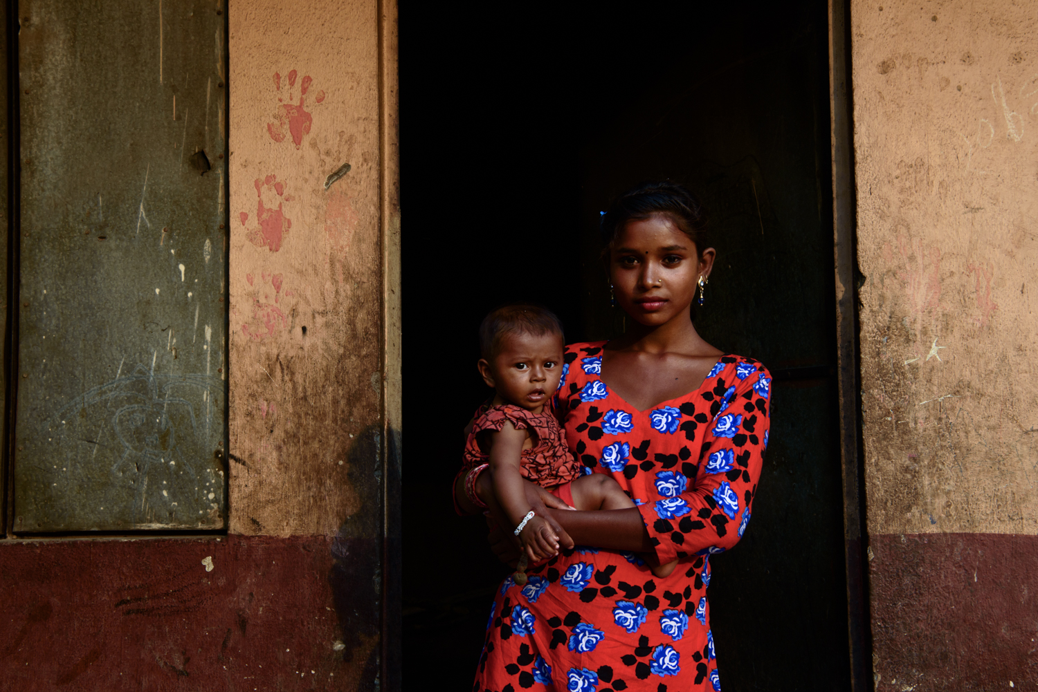  Sujita Majhi (14) holds her six month old neighbour Sumina. Sujita studied till class 5 and then dropped out of school because of her family's hard economic condition. Sujita wants to continue education but has no hope that she can do it. 