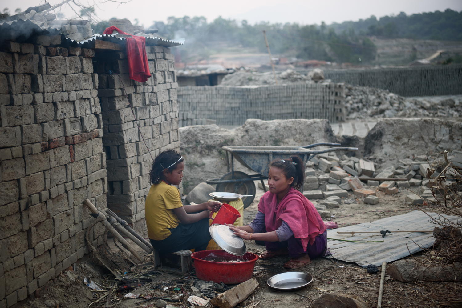  Selina Tamang (9) helps her sister Bipana Tamang (11) to wash utensils and prepare for dinner at their home in Badikhel, Lalitpur, Nepal. Bipana goes to school but Selina dropped out of school because of excessive bullying. Both the girls work in th