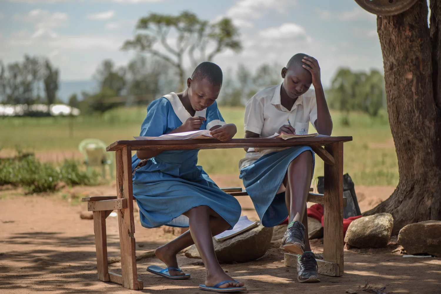 M.B., 14, (left) shares a bench with a classmate during a school examination at the Nyamotambo Primary School, Migori County. Mary is pregnant and an orphan who lives with two younger siblings. Her two older brothers who work in Nairobi send her money for her living expenses.