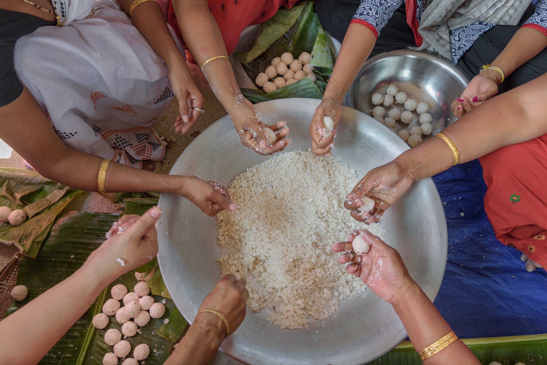  Members of the Hargila Army make ladoos, a local sweet made out of rice powder, coconut and sugar at the baby shower for the greater adjutant storks nesting in their neighbourhood at Dadara village, Assam, India.  The sweets and other delicacies are