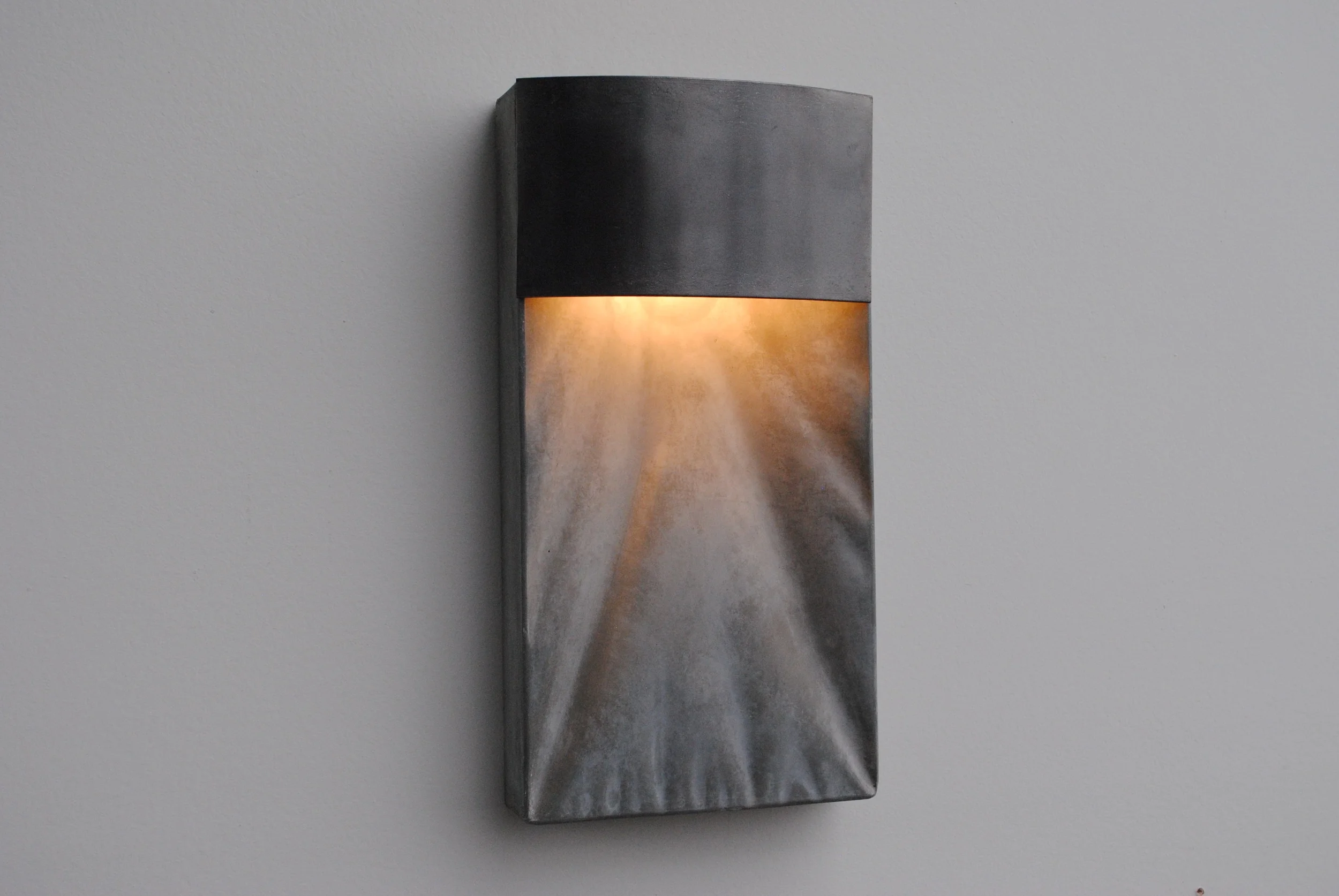  Curtain Down Light. &nbsp;This light ballances rigid steel lines against a wavy and varied concrete backdrop. &nbsp;7"X13"X3" and less than 6 lbs. 