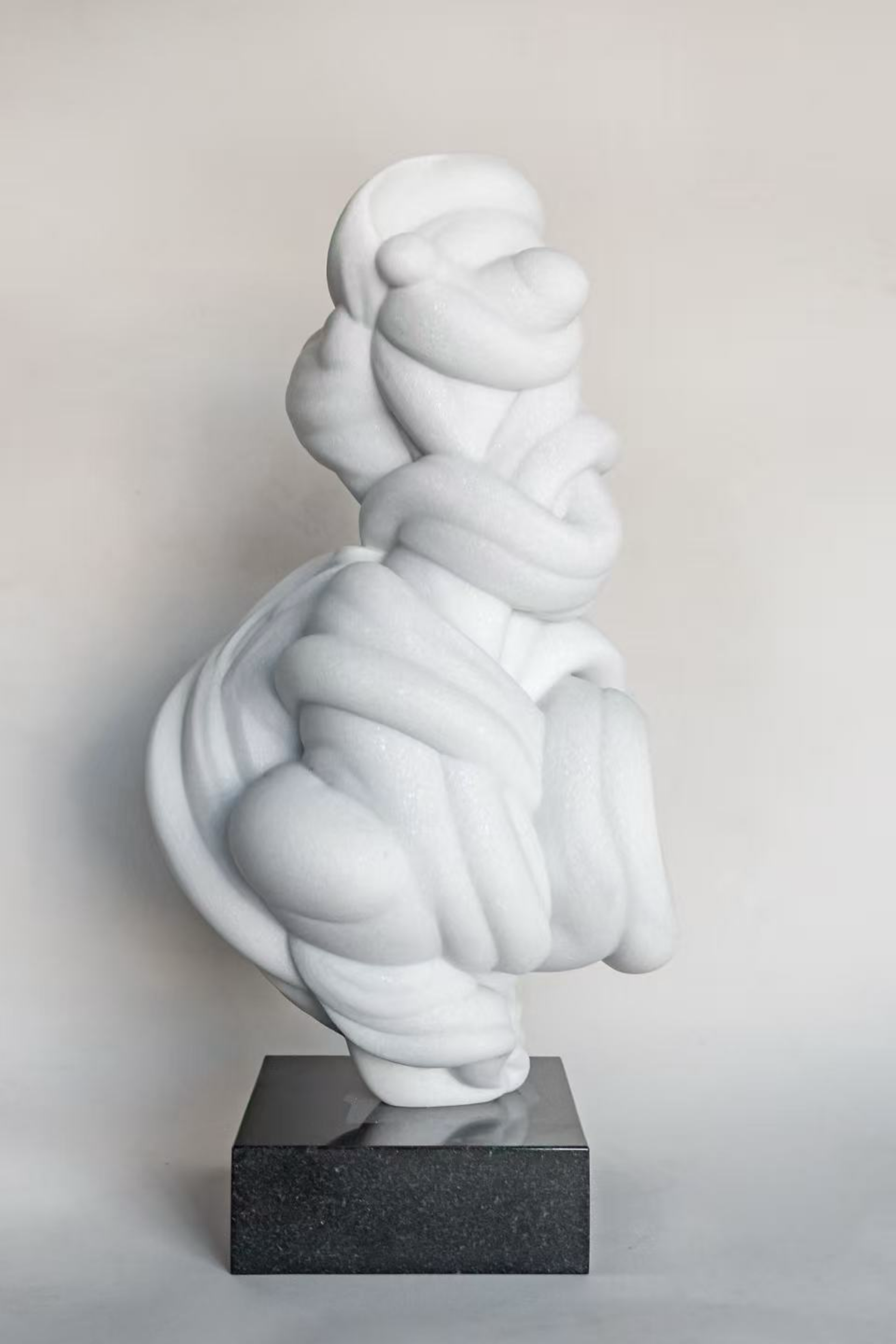 White abstract sculpture on a black base.
