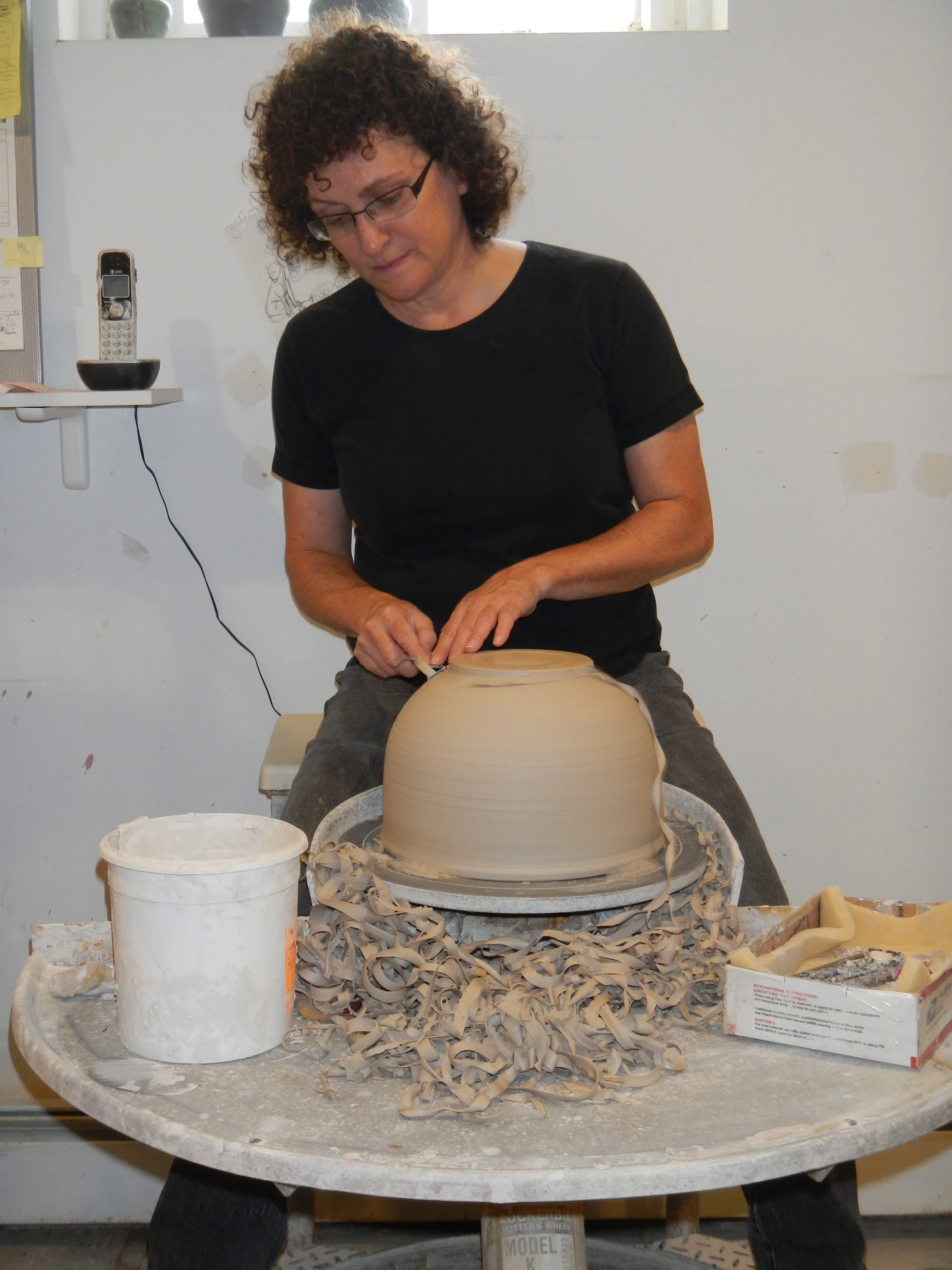 (Trimming a bowl at my trusty kickwheel. Photo Madelene Hoffman 2012)