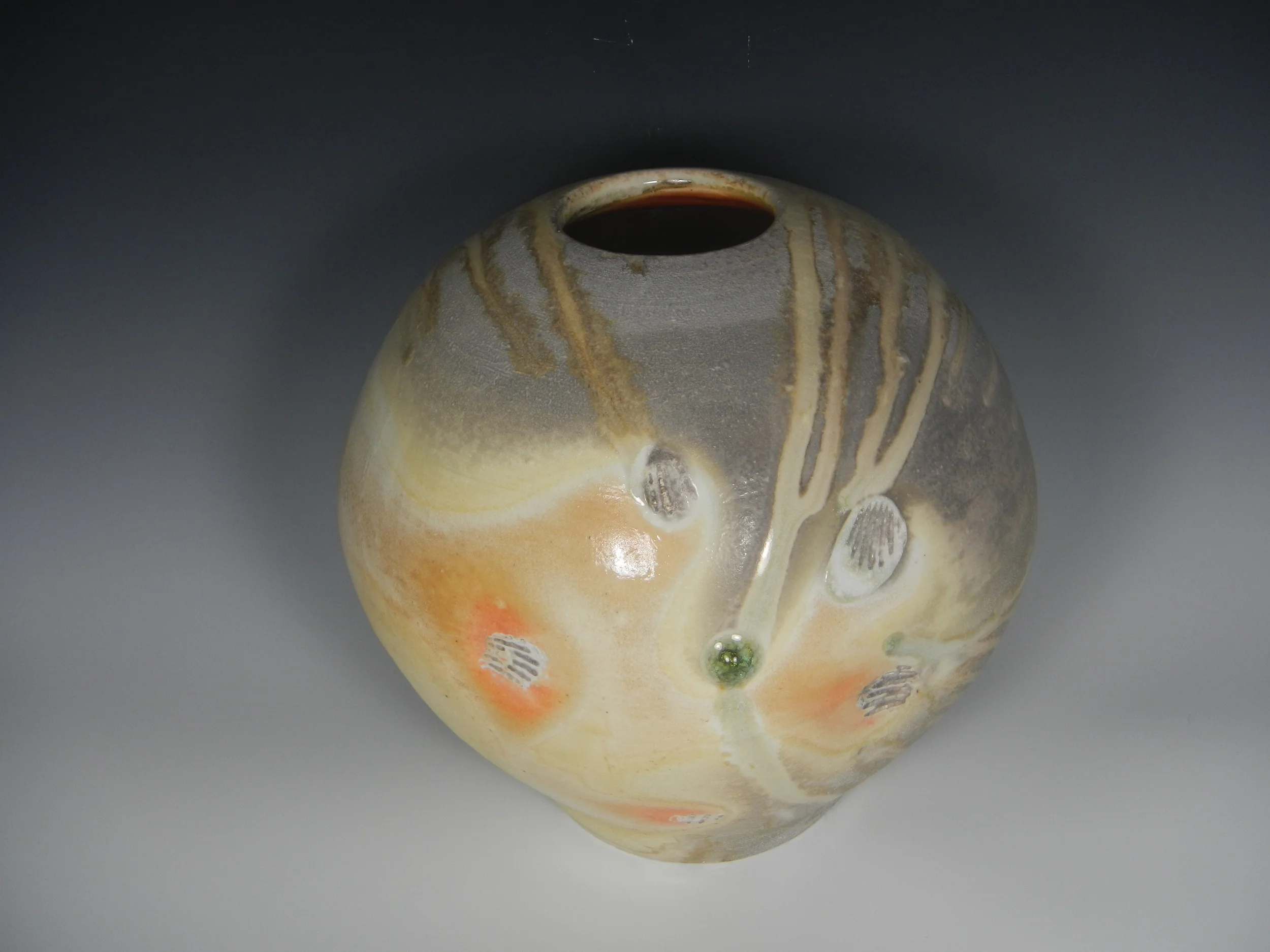 (Here is the vessel as it was displayed in the TASOC show, with its jewel of green ash-glass. The calcium in the seashells seems to have fumed as it burned away, left beautiful orange flash marks on the reactive porcelain. Photo Mimi Stadler 2014) 