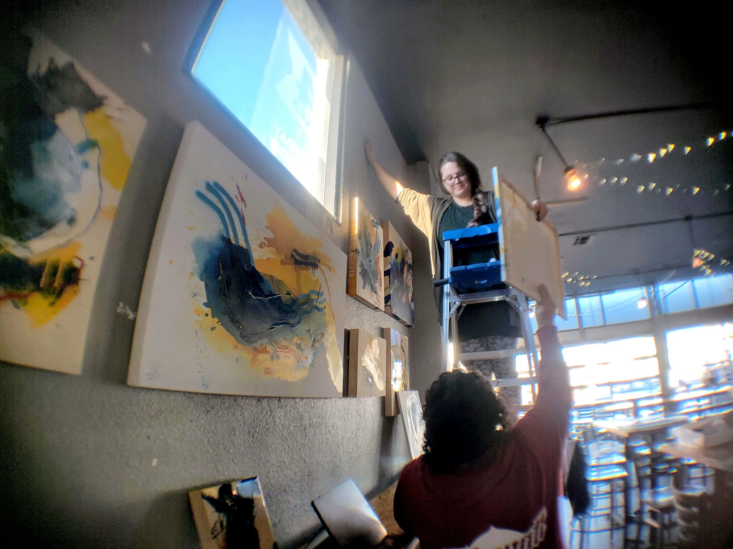 Cayce Wheelock and Em Archuleta of Hanalei Artworks installing “Intersections”