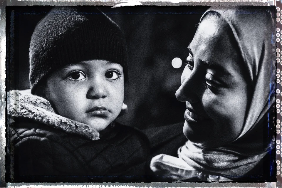 Still very young, Alzain looks intently at me "the stranger" under the close protection and trusting motherly bond. This image again reinforces the relationships we expect to see within families, Muslim or Non-Muslim.
