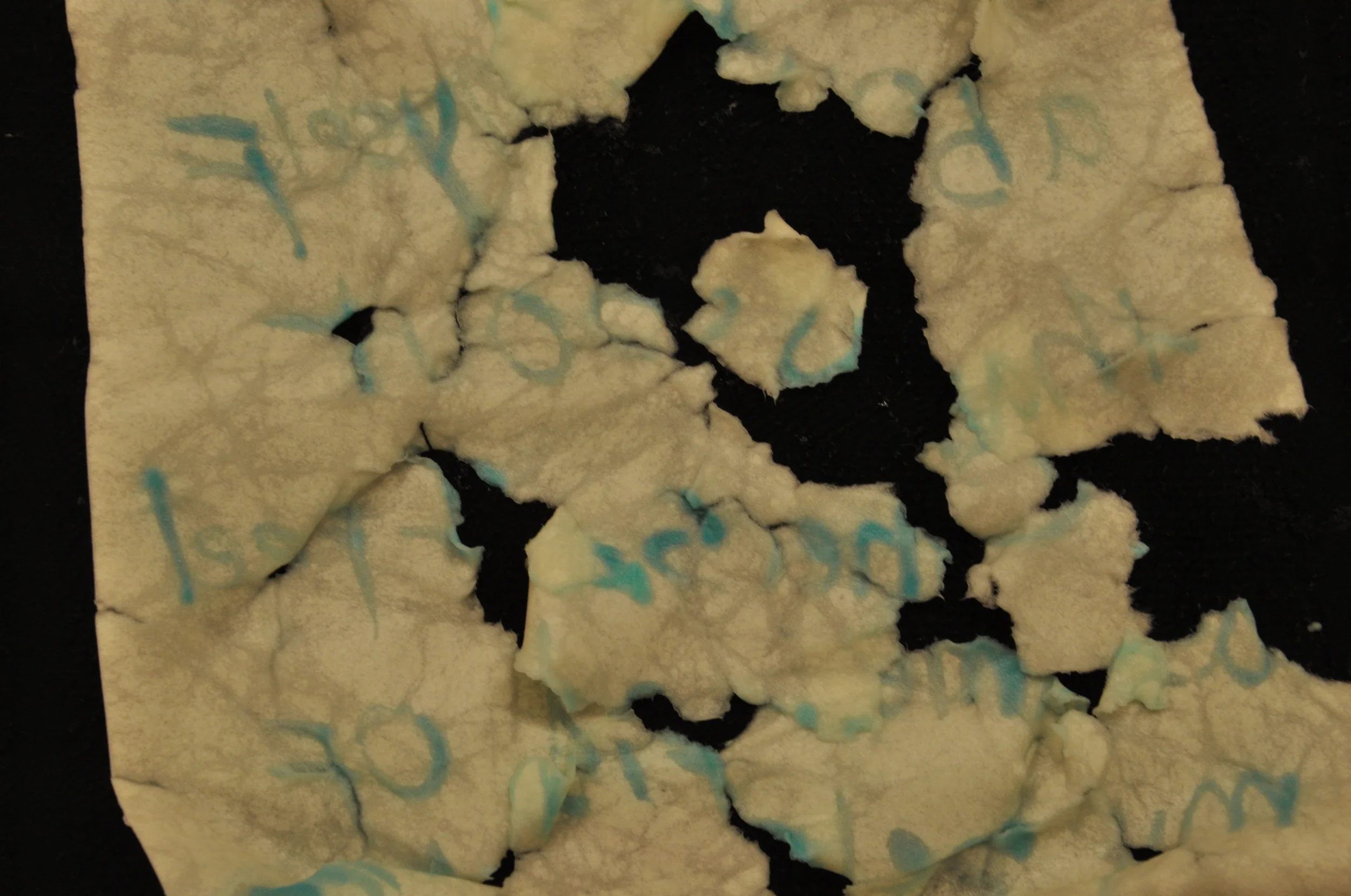  Water soluble ink creates abstract, non readable figures and text on teared paper.&nbsp; 