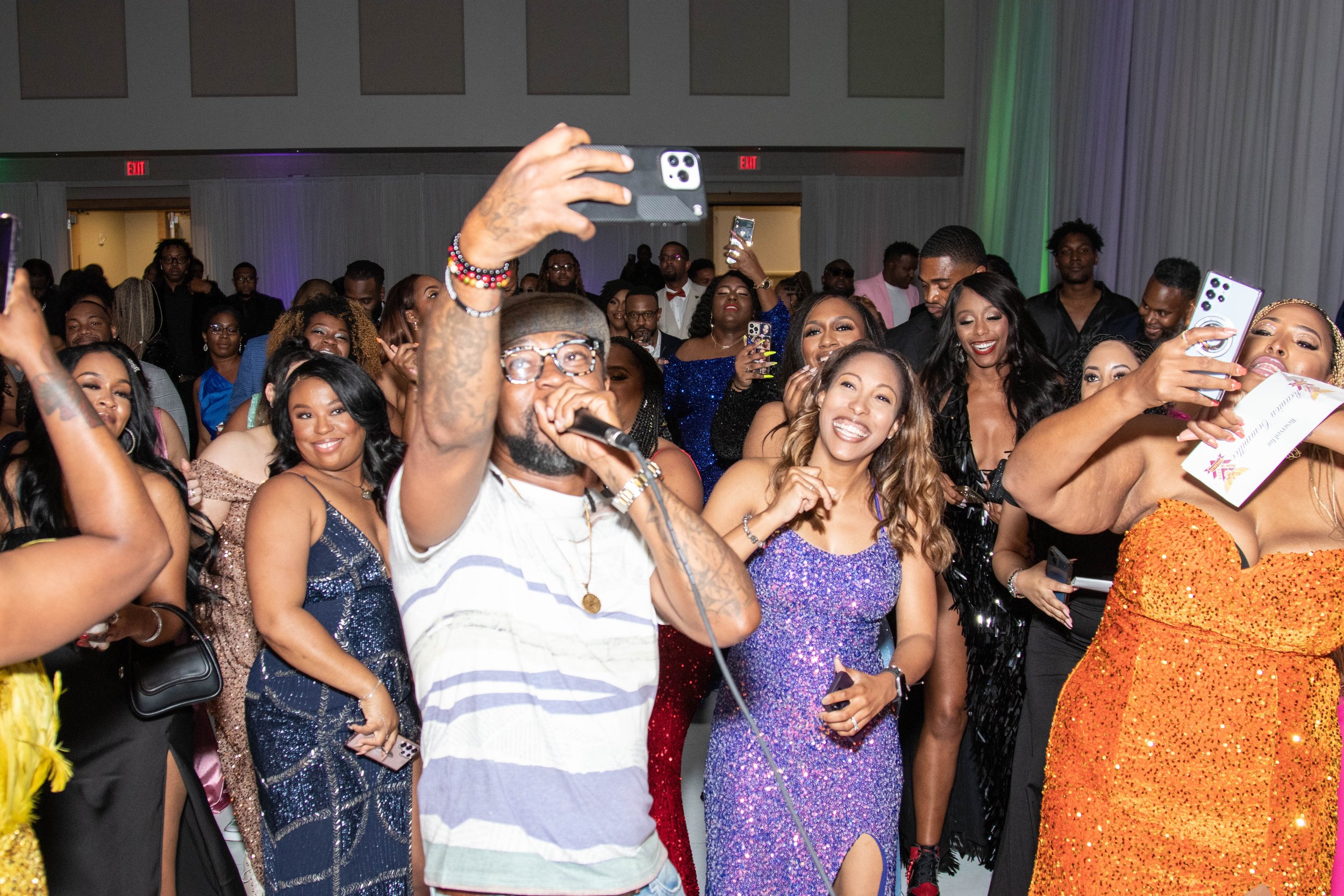 McD 35's Class of '03 enjoys a lively dance floor at their Sneaker Ball, with a guest performance in the background.