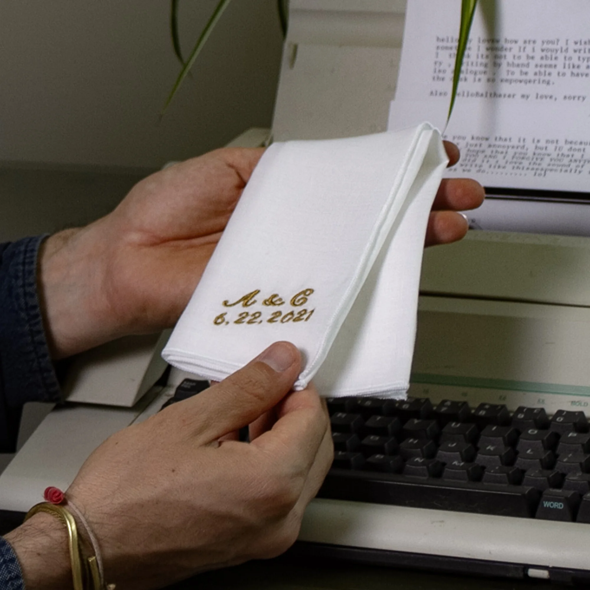 Person holding a white handwritten letter dated June 22, 2021 in front of a computer keyboard