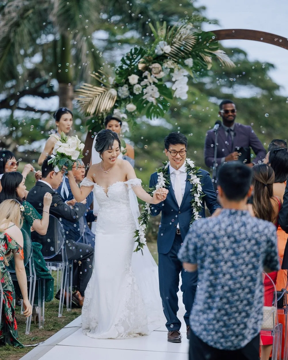 Not every wedding has a dinosaur proposal.
But this one did.

A ceremony above the ocean, framed by palms and the quiet silhouette of the island beyond.

Between the ocean breeze, the palm trees, and the distant island resting on the horizon, the ent