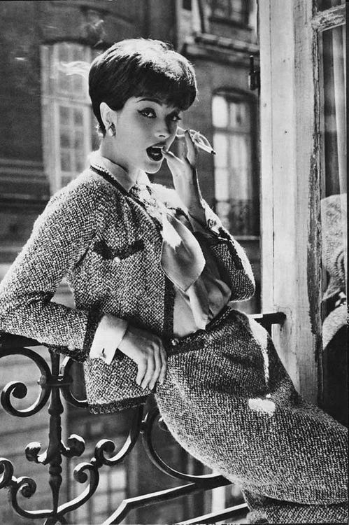 A thoroughly modern woman wearing an iconic Chanel tweed suit.