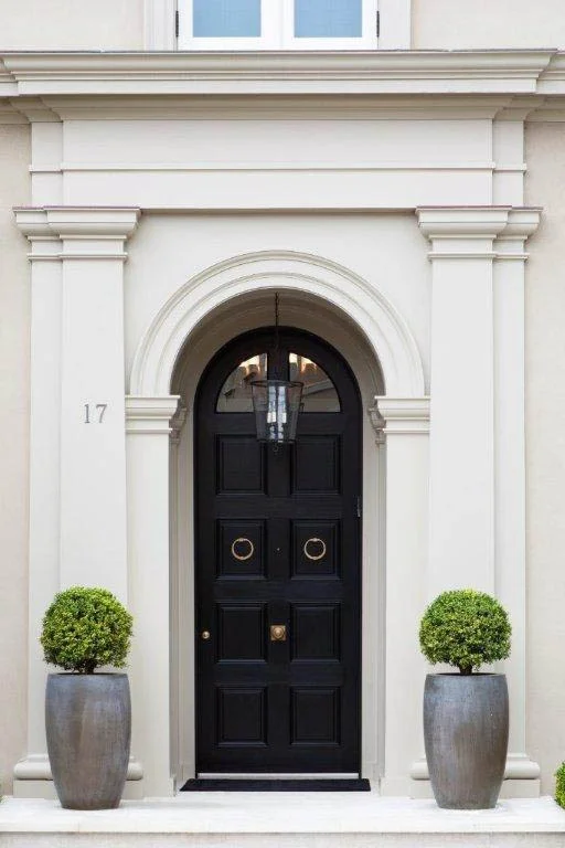 A Brilliant London Style Door in high gloss black in stark contrast to the white classical edifice.
