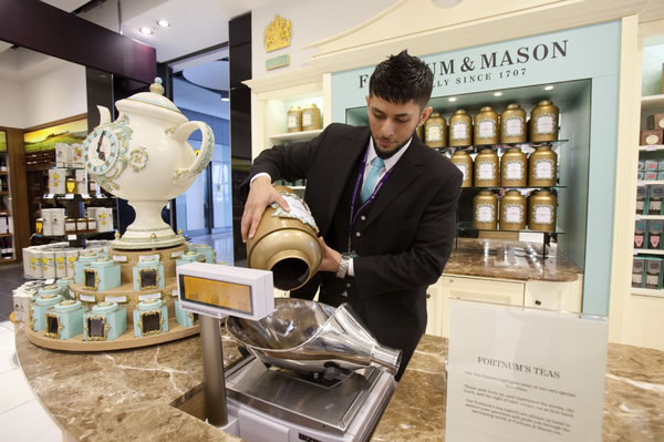Tea being carefully weighed at Fortnum & Mason, established in 1707.