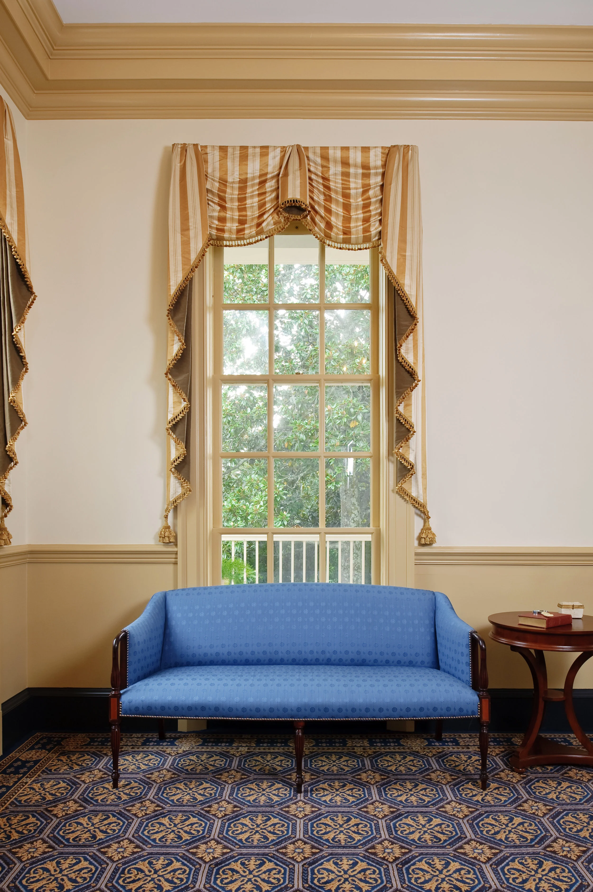 The Sheraton settee is covered in a vibrant cobalt blue, reproduction of a horsehair fabric by Brunschwig et Fils. The traditional window treatment is in a Scalamandre silk.