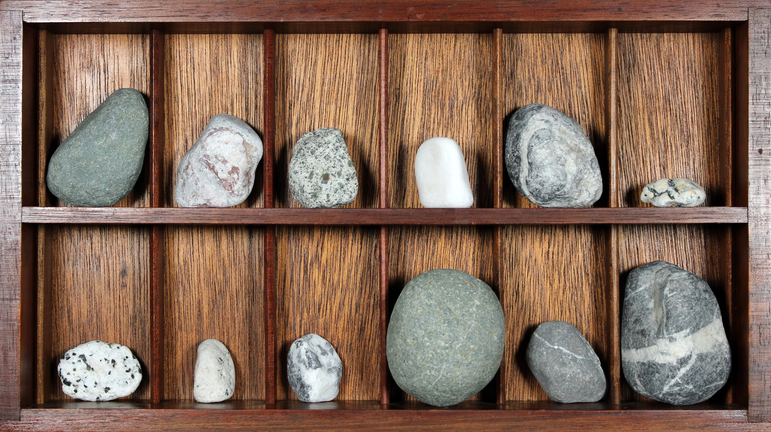    Cloak (interior unit),   2026  Found objects (vintage wooden rack, rocks)  8 1/4 × 15 × 2 1/4 in  Component of site-specific installation   