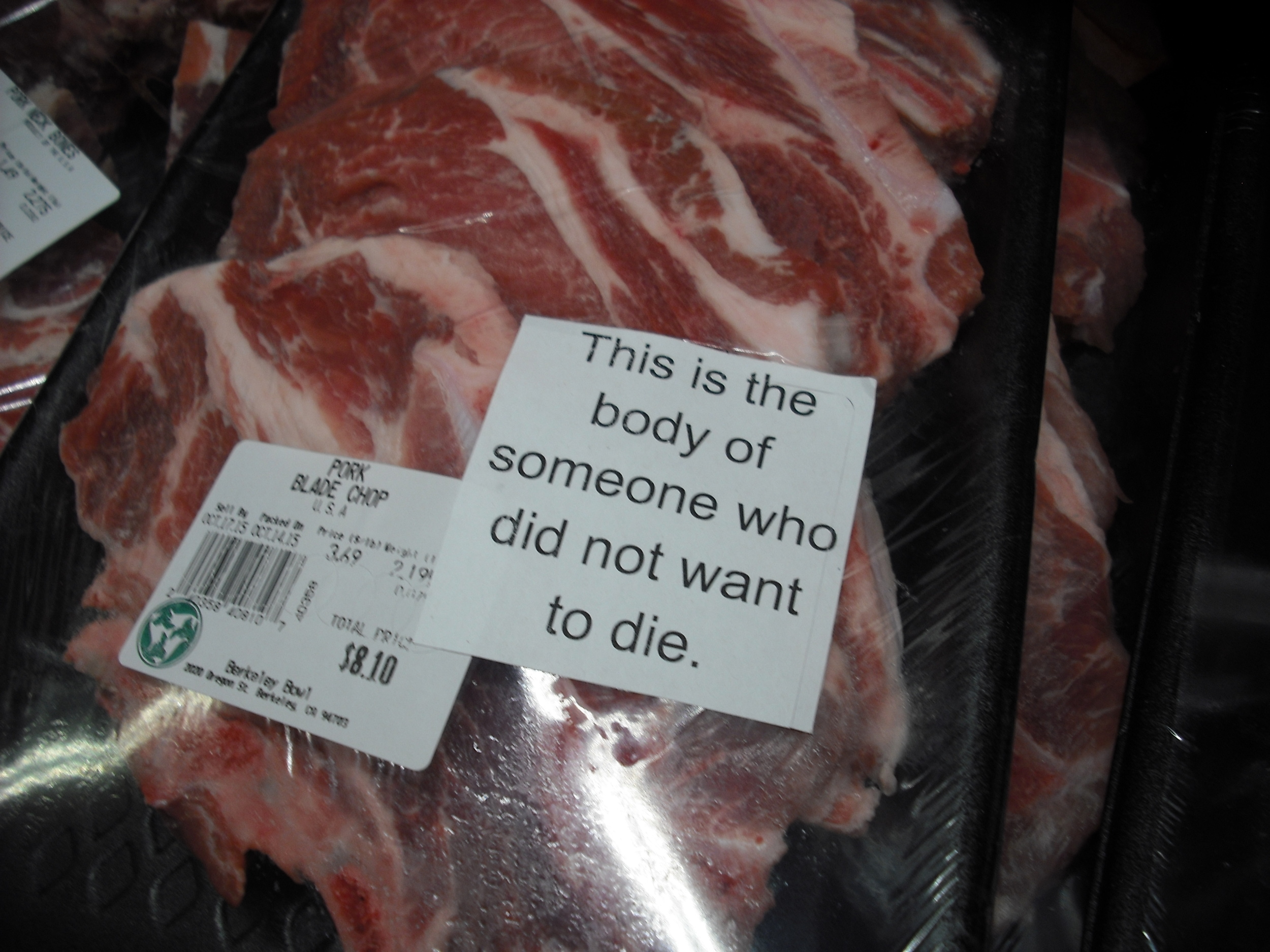 A package containing animal flesh has a sticker on it that reads "This is the body of someone who did not want to die."