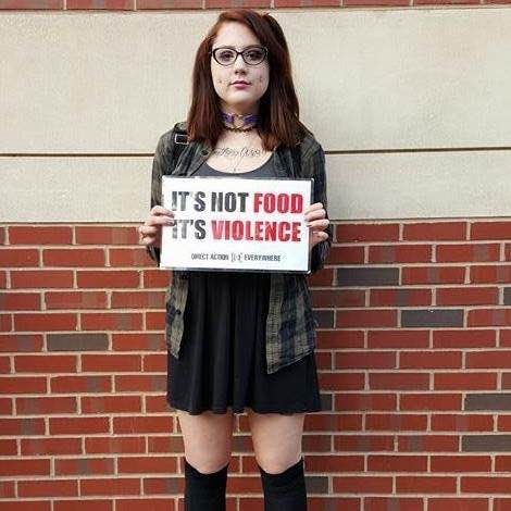Keira Devine, organizer for Direct Action Everywhere Philadelphia, holding an "It's Not Food, It's Violence" placard.