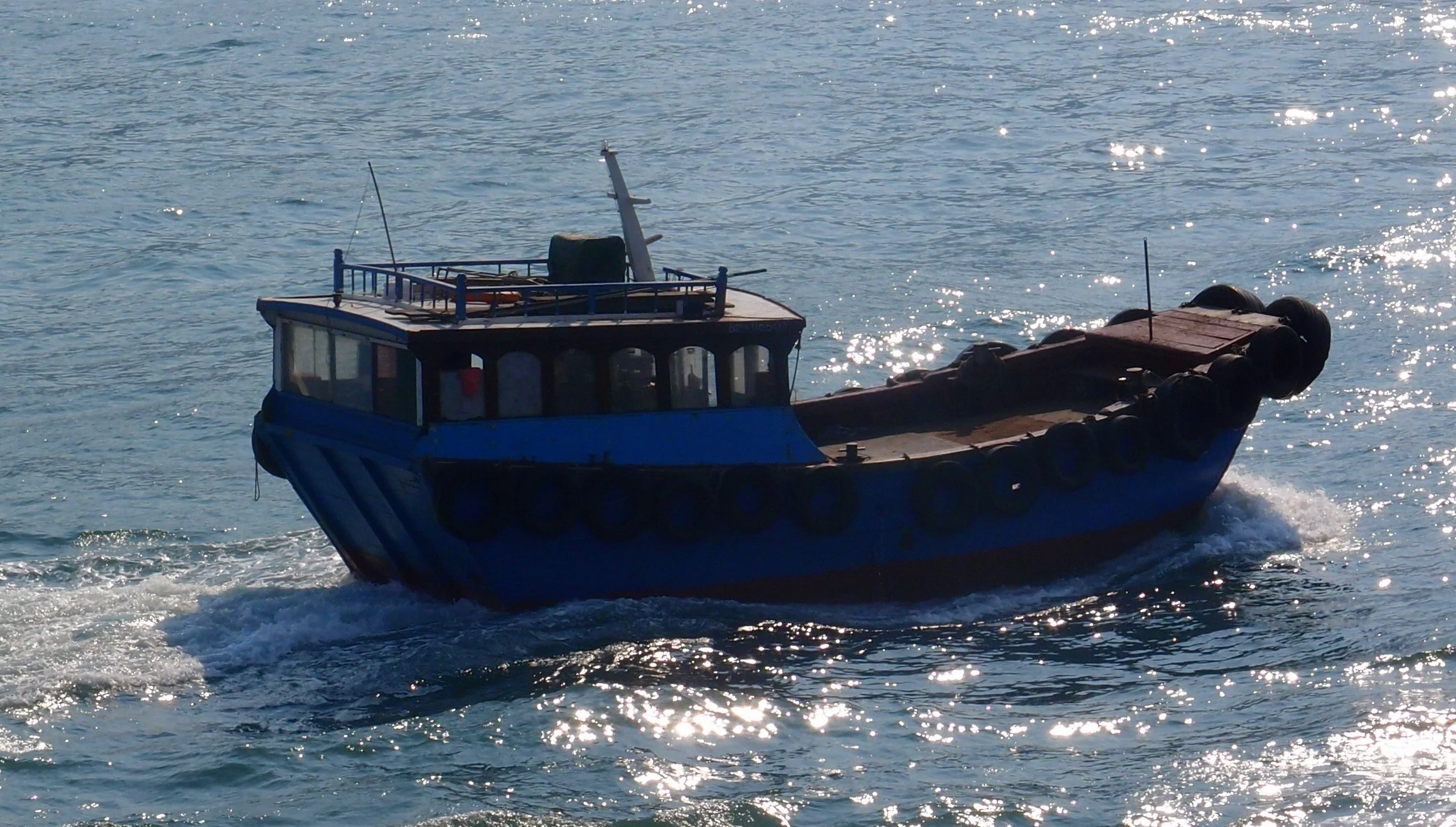 A small boat bobbing around in Hong Kong harbour