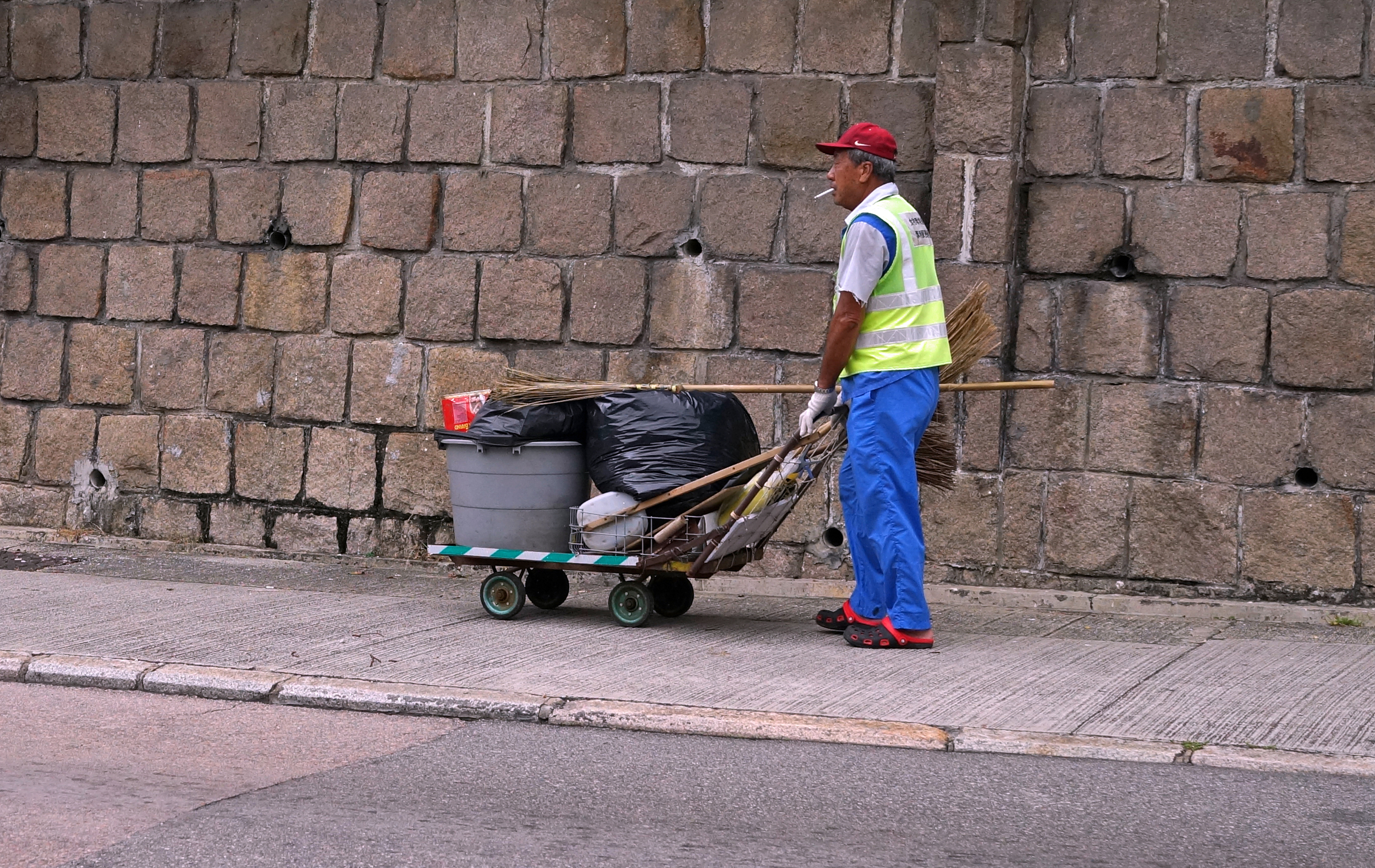 Street sweeper having a fag opposite the Hong Kong Country Club, probably the highlight of his day