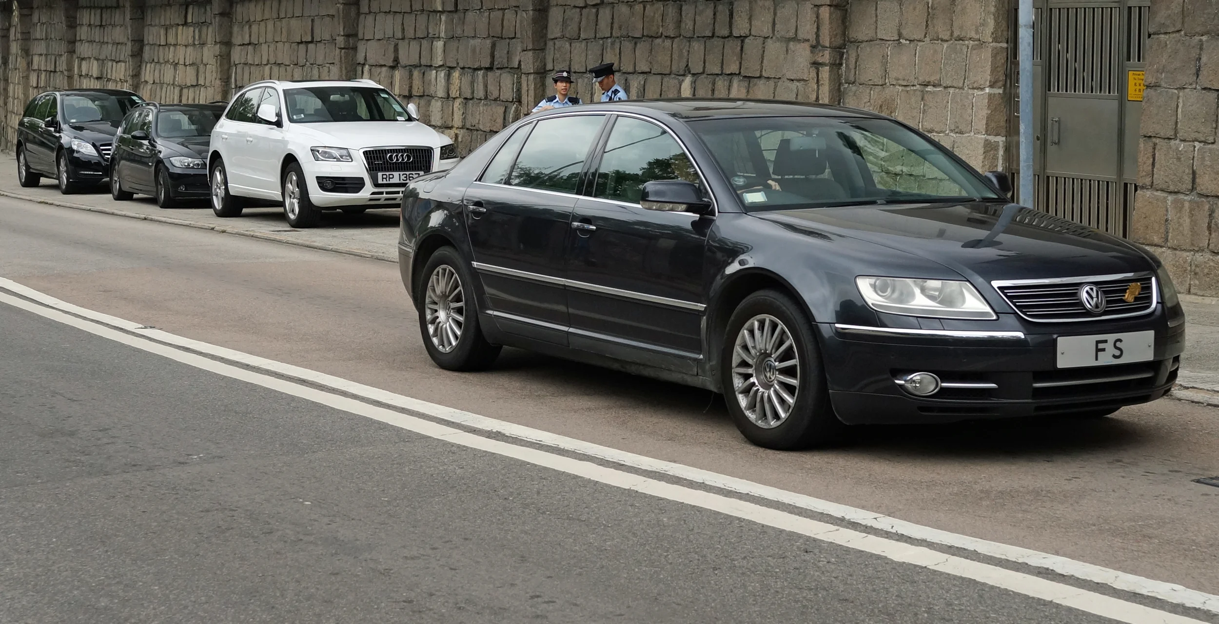 Sometimes the Police take action against cars parked illegally (here at the Hong Kong Country Club) also the car whizzing by with the number plate FS is our Financial Secretary! I often see him on a Sunday in his official car.