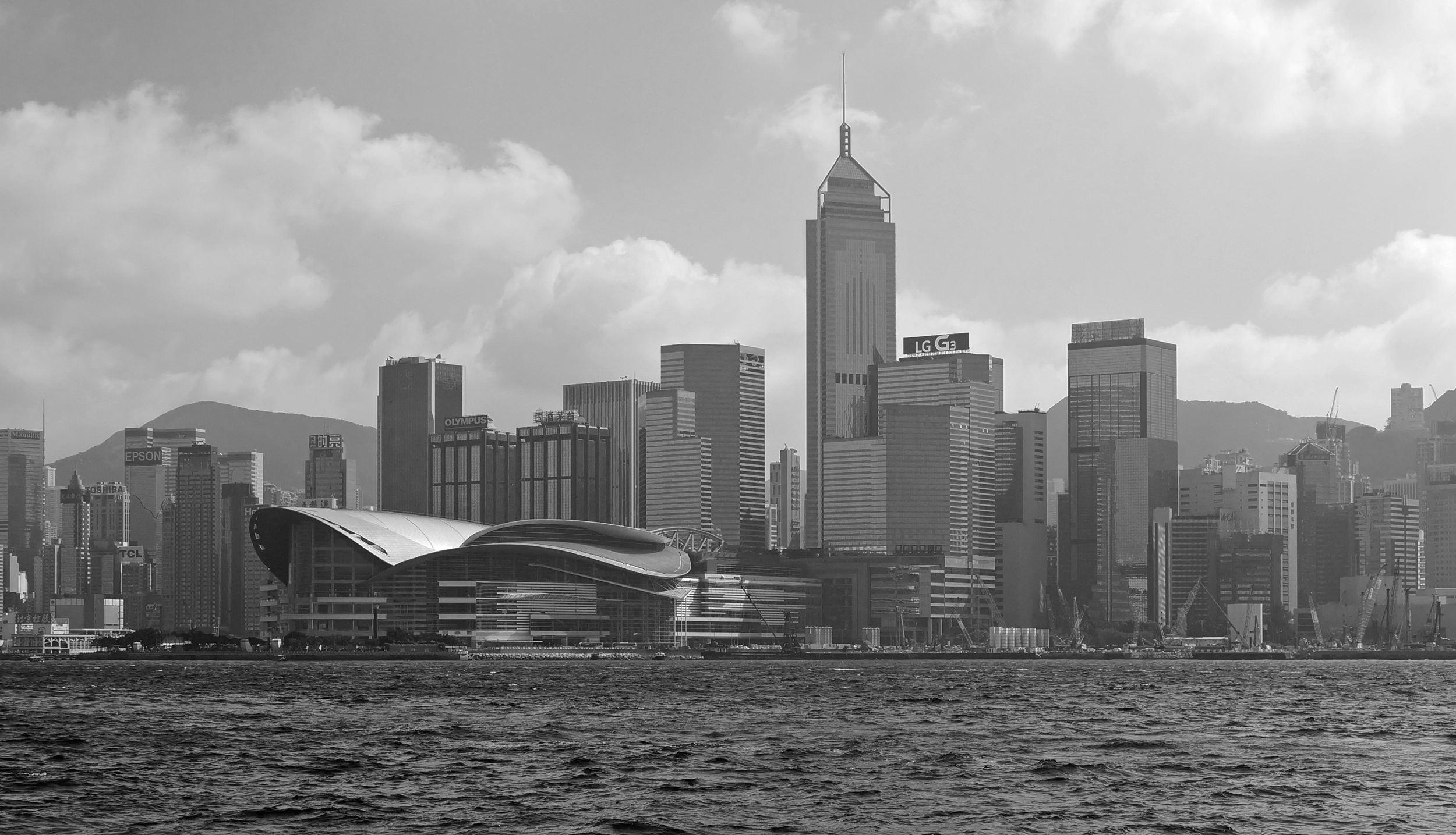 A black and white hazy view of the Convention Centre on Hong Kong Island -