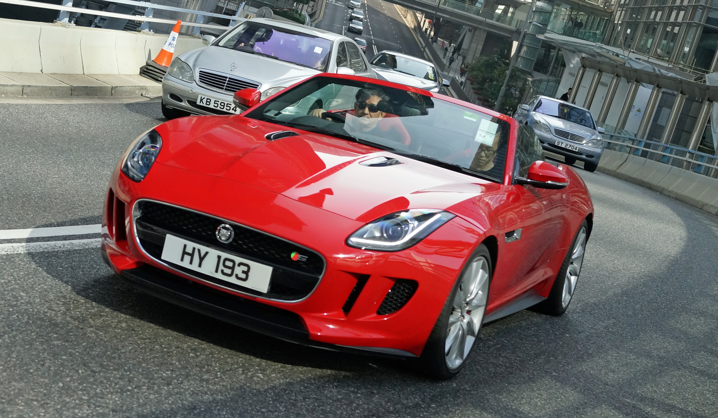 I do like the Jaguar - I am pretty sure the chap driving this splendid example is George Tam a famous Hong Kong crooner!
